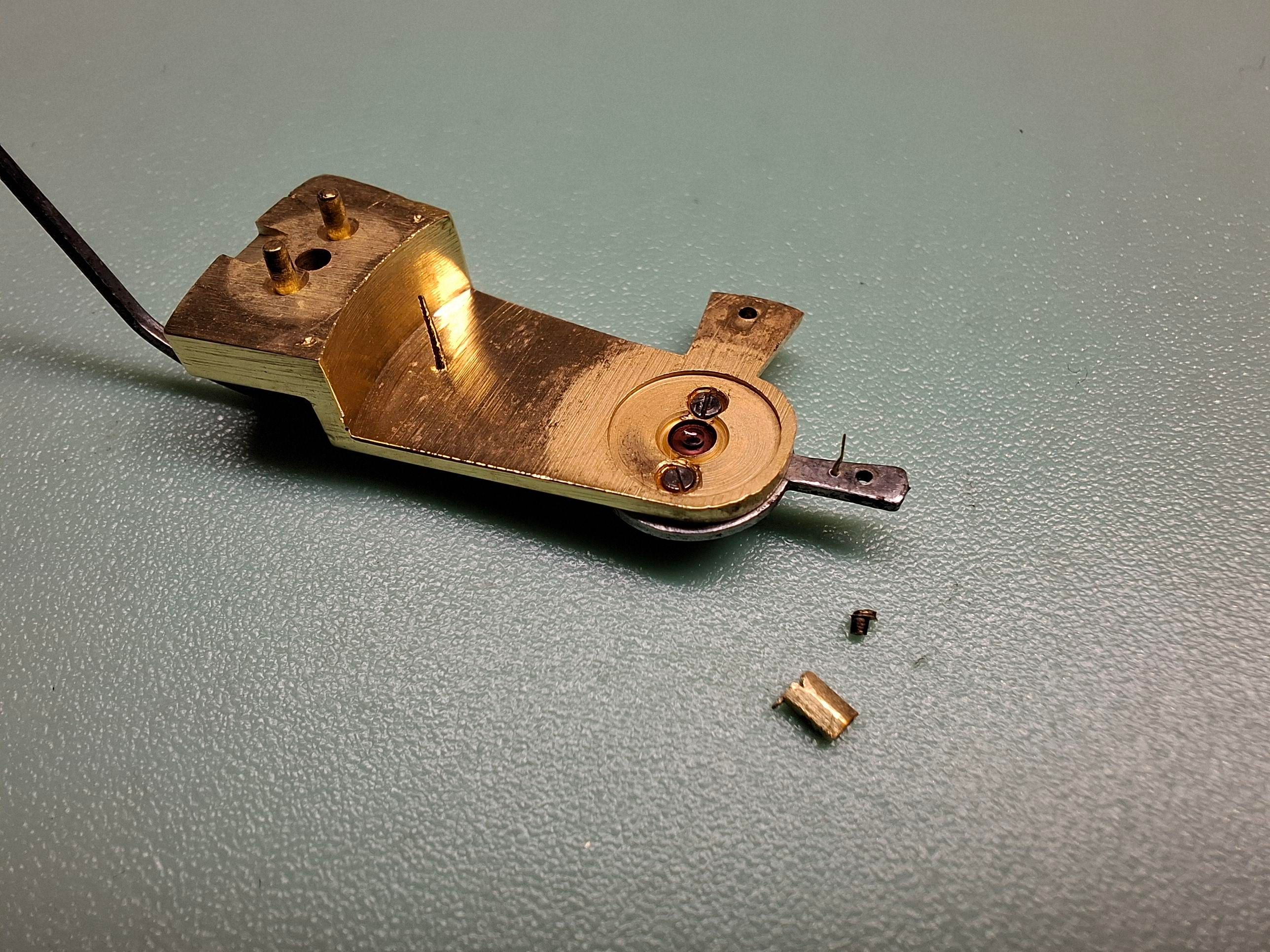 Clef de goupille cassée sous la raquette de réglage du balancier-spiral.
C'est un pont de balancier à l'envers sur la photo