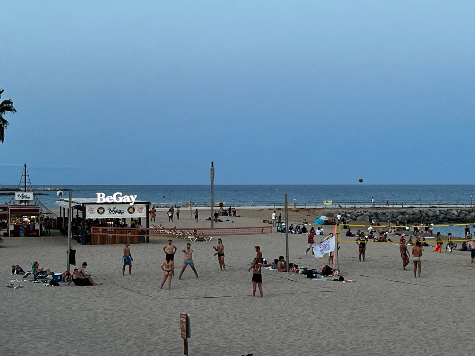 Mar Bella beach in Barcelona, a beach bar with a white neon sign „BeGay”