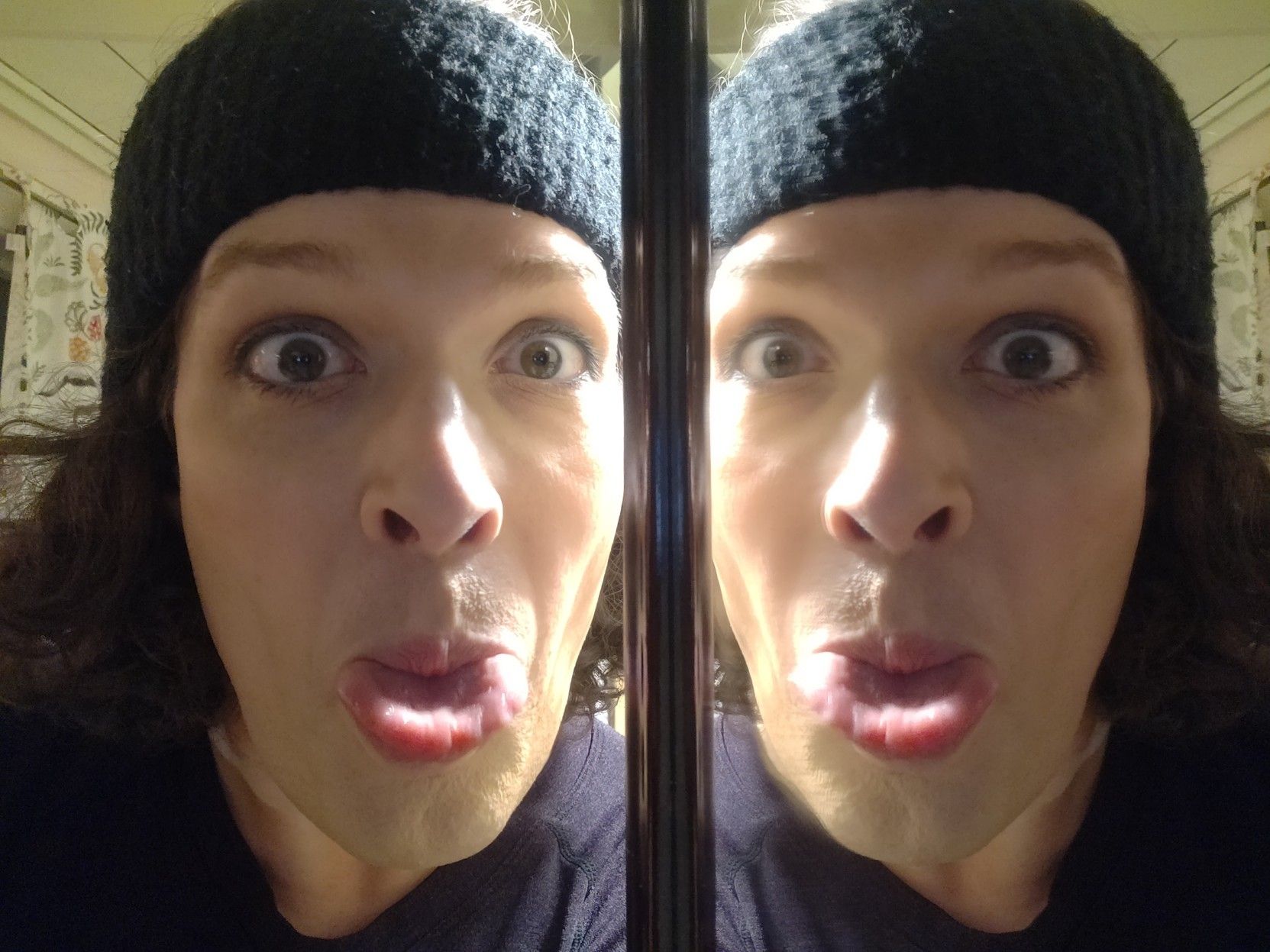 Sticking my tongue out, right beside a mirror so there's two of me doing it, my hair held back by a thick black sweat band