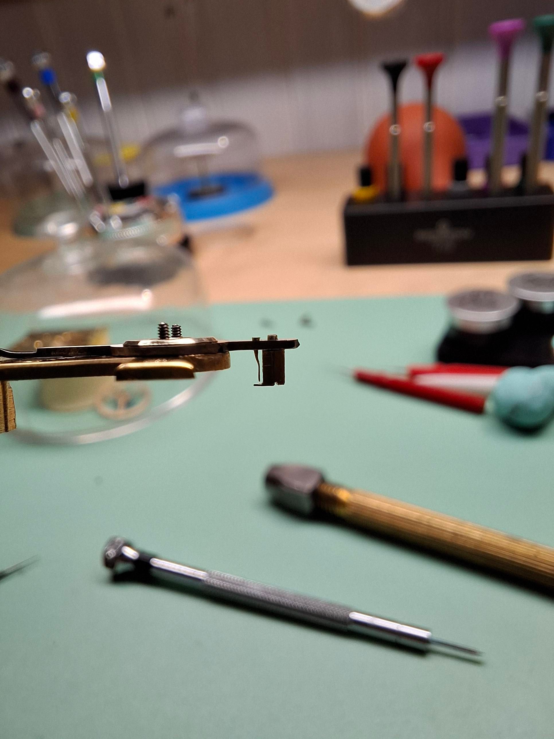 Clef posée et rivetée. 
Avec un tournevis, elle pivote pour laisser passer le spiral puis pivotement en sans inverse pour la refermer.