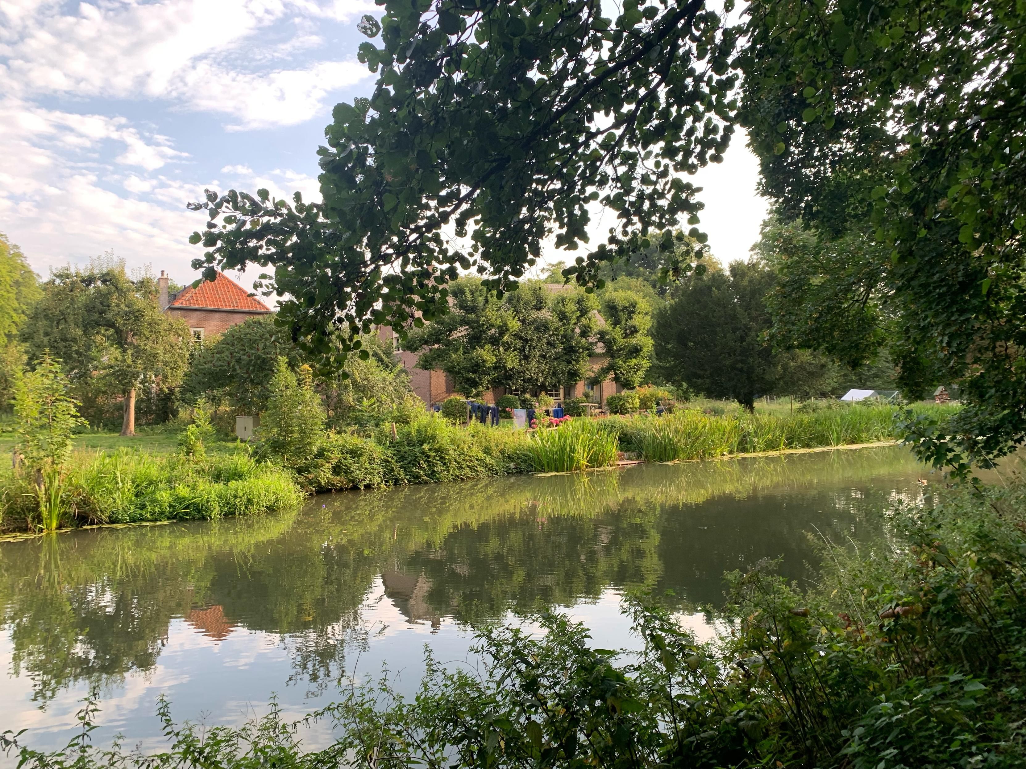 Liefelijk terrein op landgoed Rhijnauwen, een huis met rieten dak, bomen in de tuin en was aan de waslijn. En dit allemaal langs de Kromme Rijn.