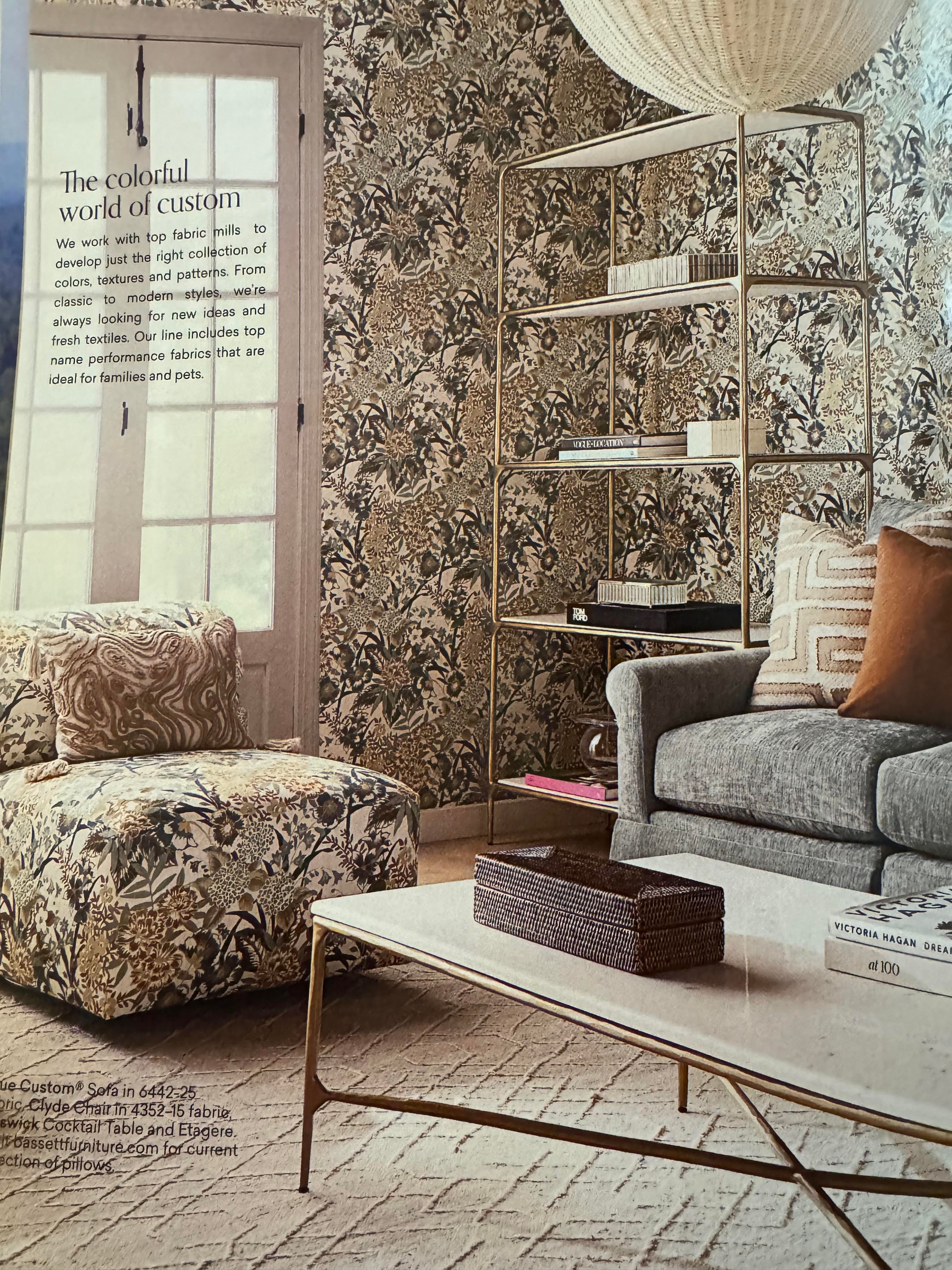A page from a Bassett Furniture catalog, showing a large-scale floral print on wallpaper and upholstered chair.  It is, perhaps, a lot of one pattern for a room, and hearkens back some decades to when this kind of "matchy" style was in style, as apparently they are trying to make happen again.