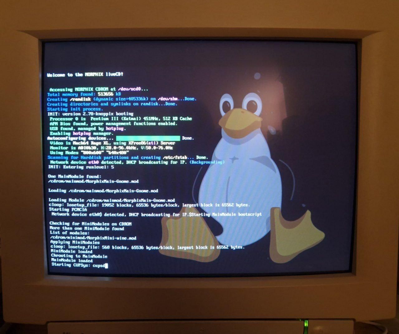 "Welcome to Morphix LiveCD" debug screen as seen on a CRT screen, with a huge penguin Tux as the background for the text