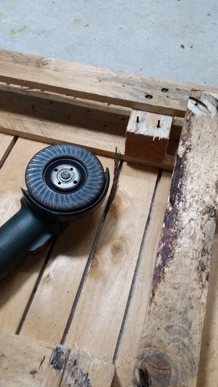 Bancale capovolto, con traversa centrale rimossa.
A fianco smerigliatrice angolare con disco lamellare.