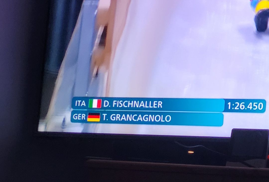 a corner of a tv screen, showing that D. Fischnaller represents Italy, and T. Grancagnolo represents Germany