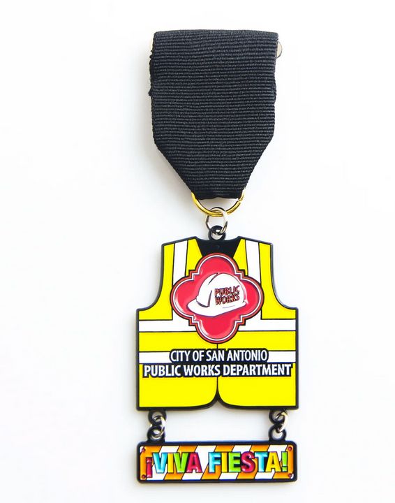 A ribbon pin for san antionio public work department features a black ribbon and colorful enamel pen of a yellow safety vest. 