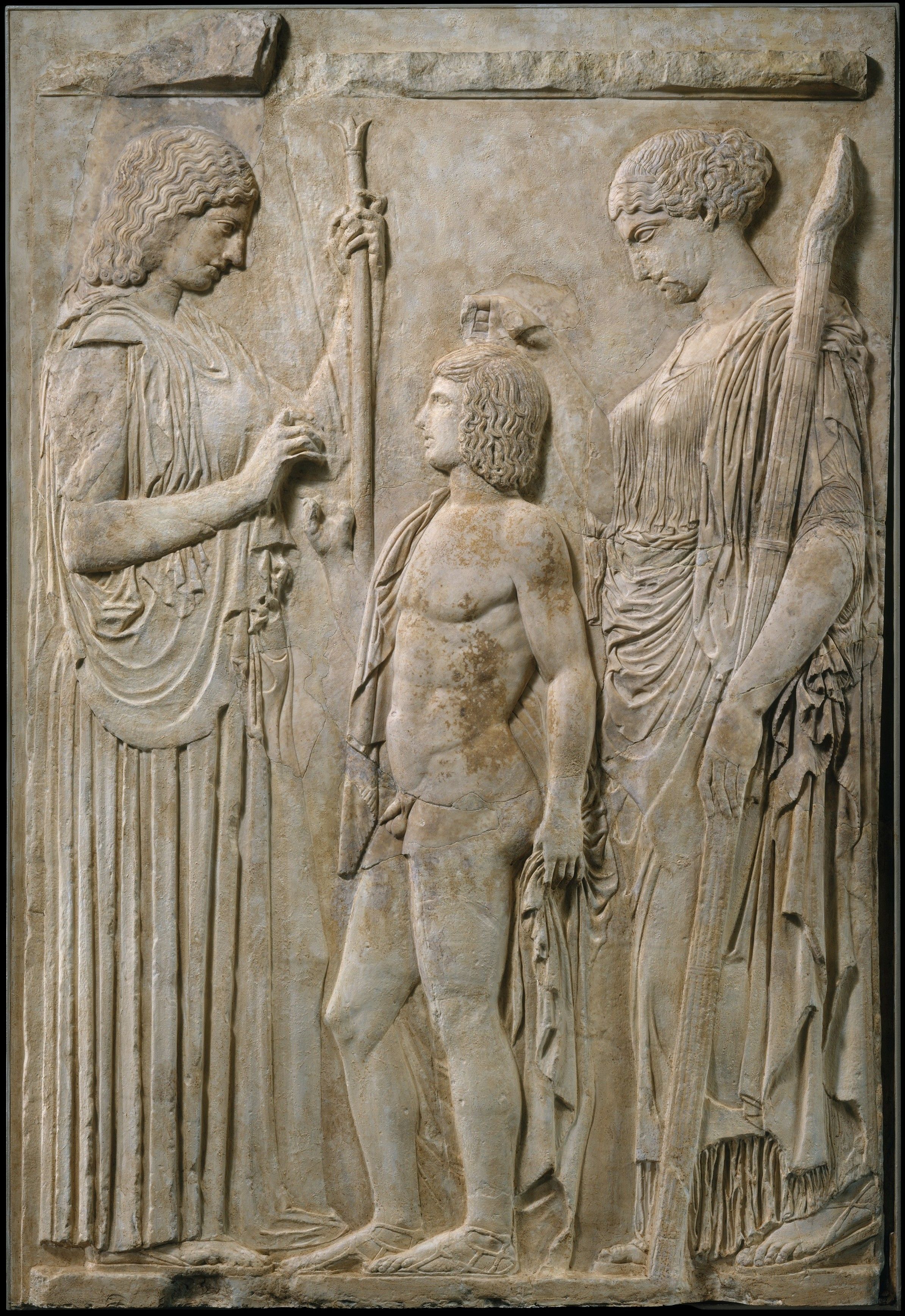 Description from the Met: “Demeter, the goddess of agricultural abundance, stands at the left, clad in a peplos and himation (cloak) and holding a scepter. At the right is Persephone, her daughter and the wife of Hades, the god of the underworld. She is dressed in a chiton and himation. Each goddess extends her right hand toward a nude youth, but it is no longer possible to determine what they held. The boy is thought to be Triptolemos, who was sent by Demeter to teach men how to cultivate grain. The original marble relief was found at the sanctuary of Demeter at Eleusis. The original Greek work and a number of Roman copies survive. Here the ten Roman fragments are embedded in a cast of the Greek relief.“