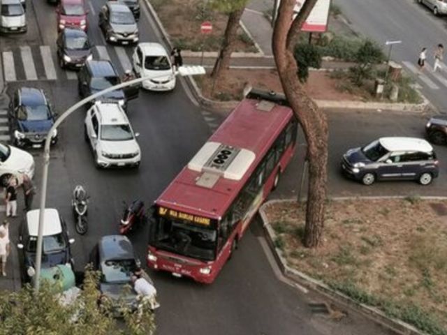 auto parcheggiate irregolarmente su un marciapiede di Roma, ostacolando il passaggio dei pedoni e dei mezzi pubblici