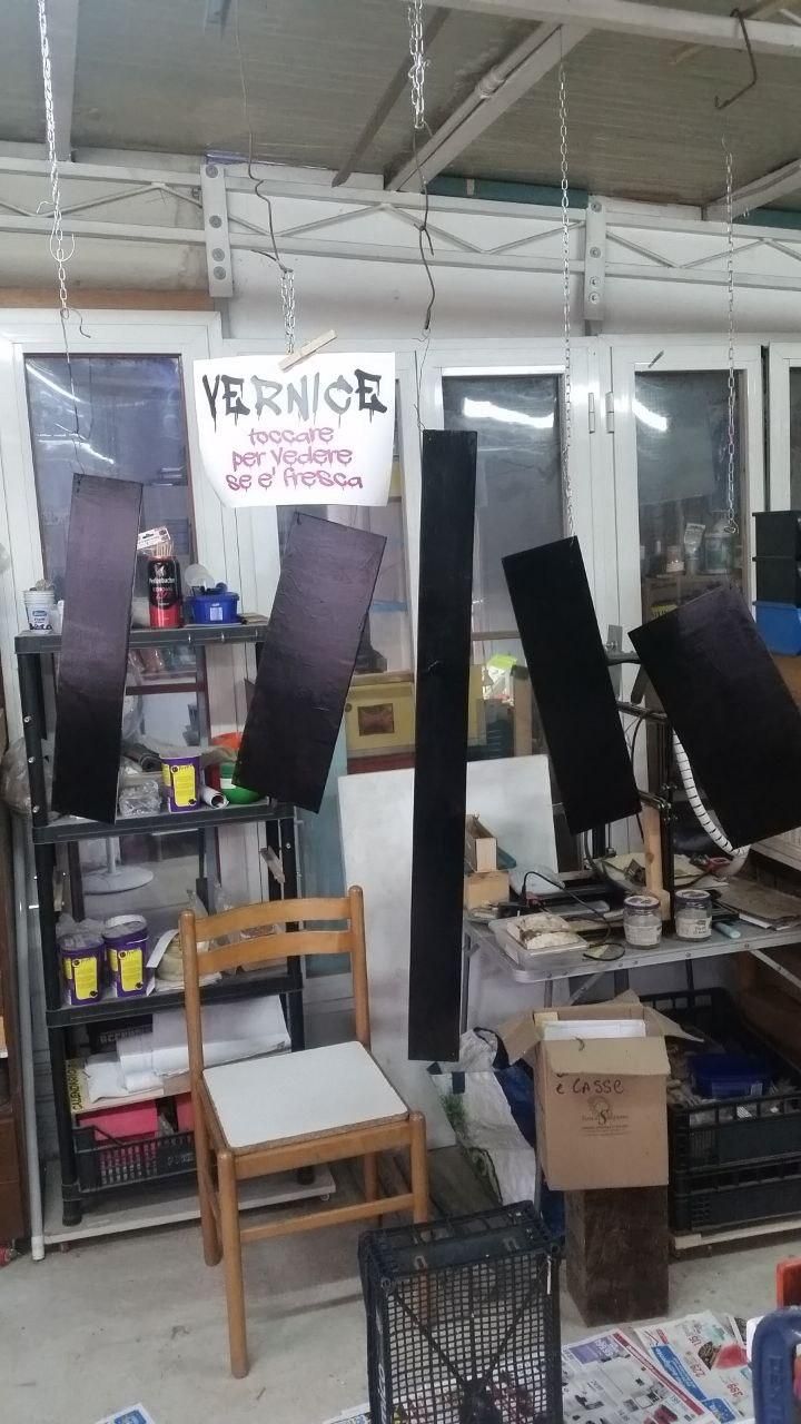 Cinque pannelli di compensato appesi al soffitto, con cartello "VERNICE - toccare per vedere se è fresca".
Il colore è molto più saturo della prima mano.