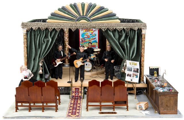 A diorama showing a band on a stage with chairs in front of it.