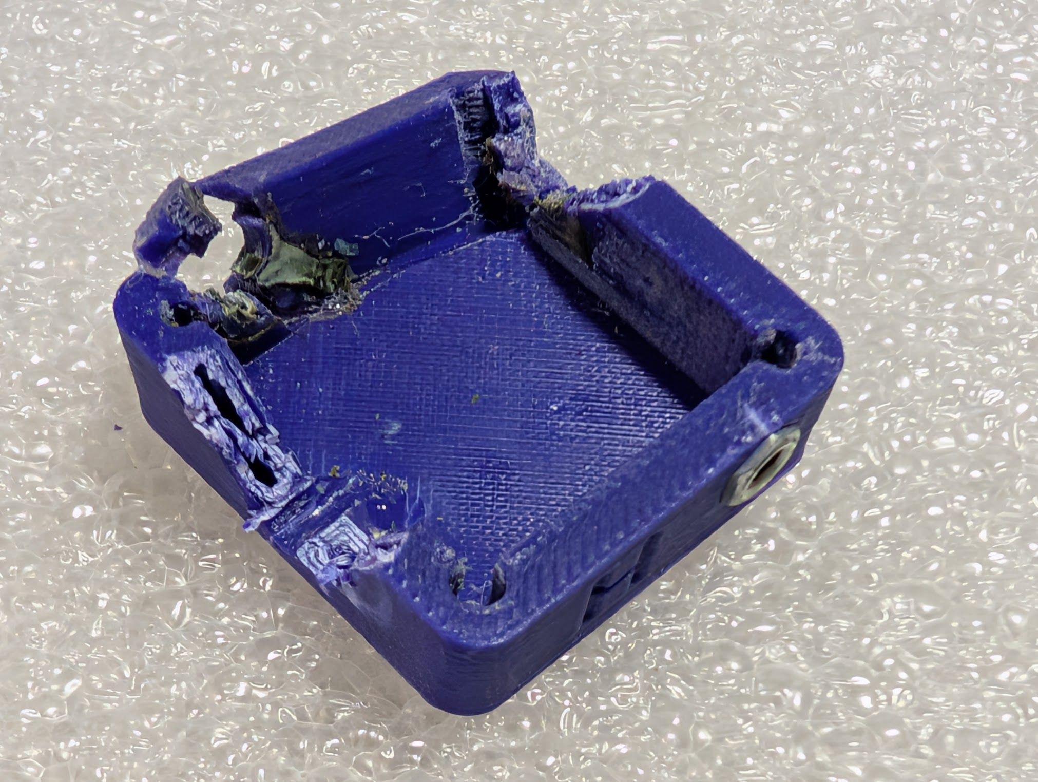 Damaged case with one side cracked off and pieces cut out for destructive disassembly to save the electrical parts for a new case.