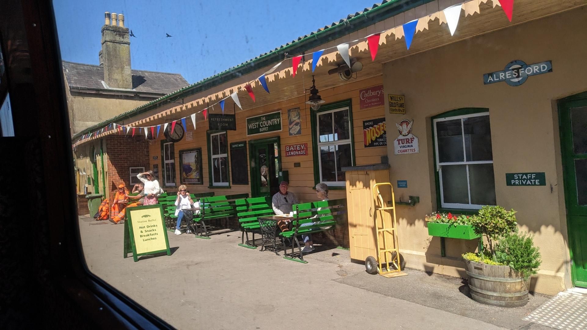 Arriving at Aldersford, yellow decorated station with green benches