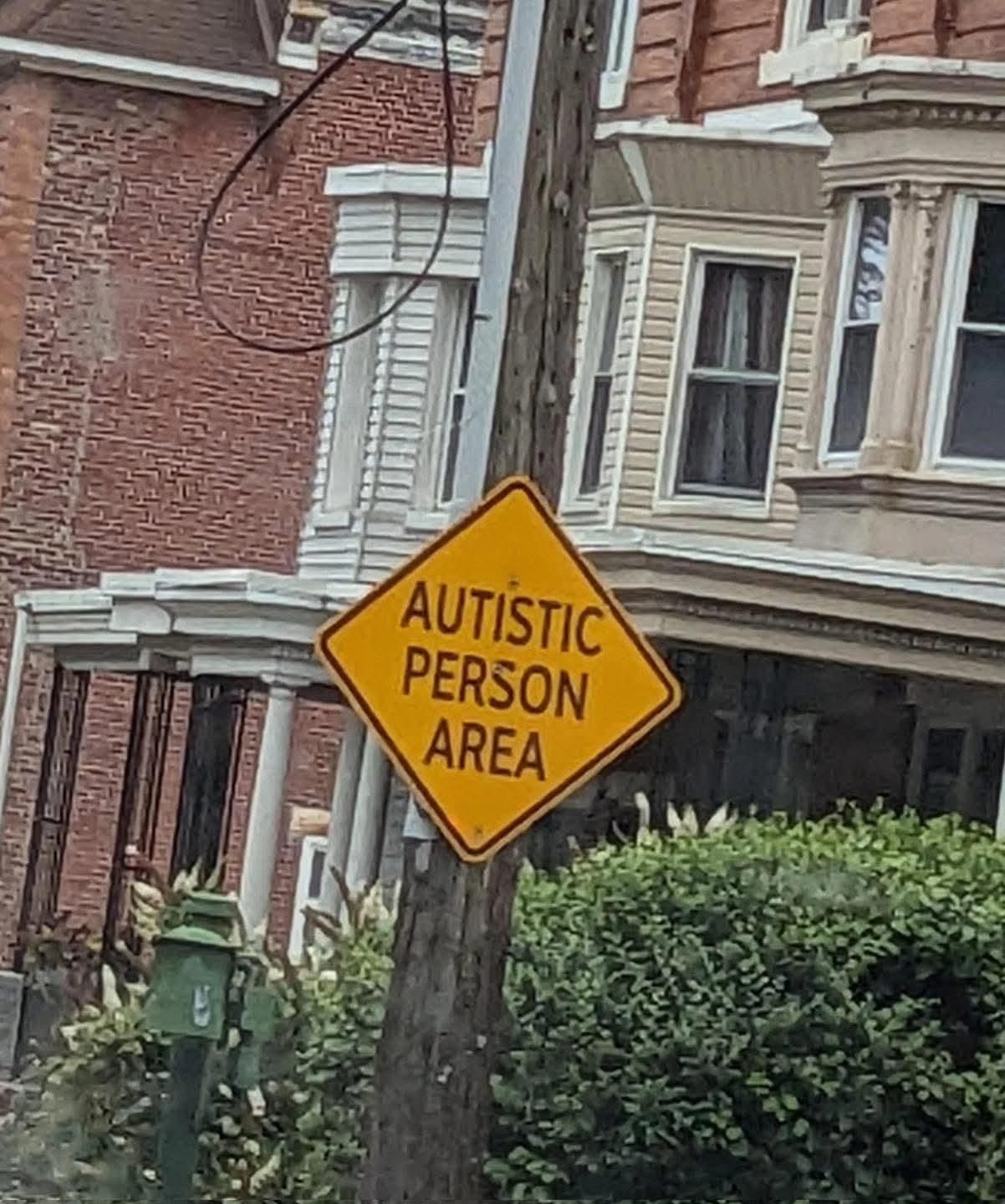 a street sign saying "AUTISTIC PERSON AREA"