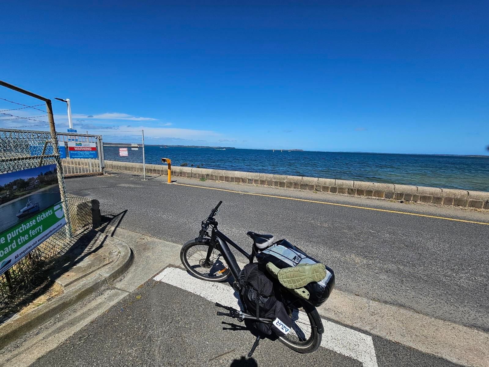 My ebike parked at Stony Point, with clear blue skies and the sea in the background.