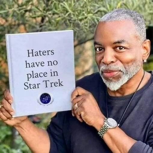 #StarTrek 
Levar Burton (TNG-Charakter Geordi LaForge)
Hält ein Buch mit dem Titel
"Haters have no place in Star Trek" hoch