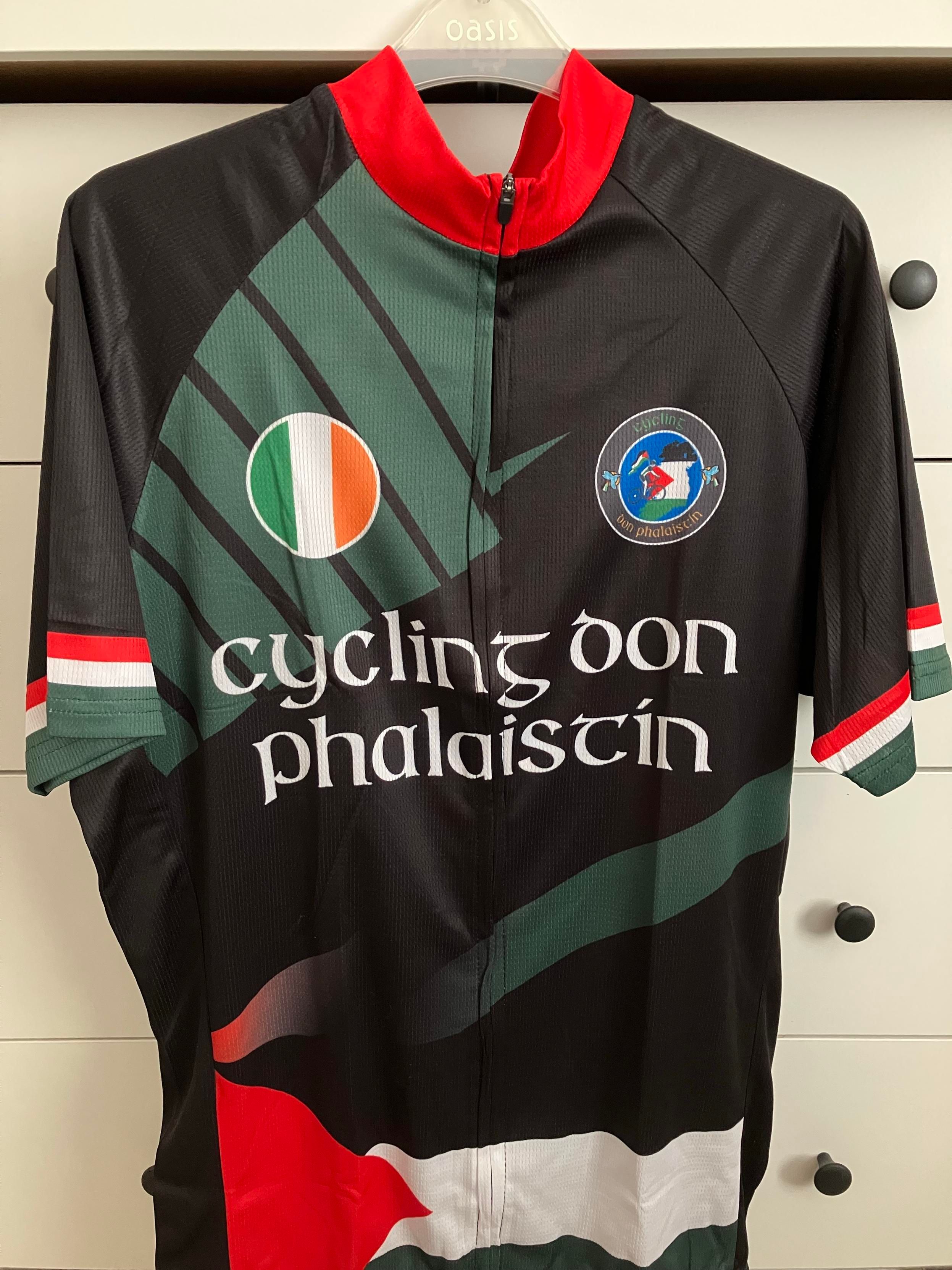 A photo of the event jersey, in colours of the flag of Palestine, and incorporating the flags of Ireland and of Palestine, as well as the logo of the Lapwing Sunbirds Cycling Club. Written on the jersey is "Cycling don Phalaistín," meaning "Cycling for Palestine."