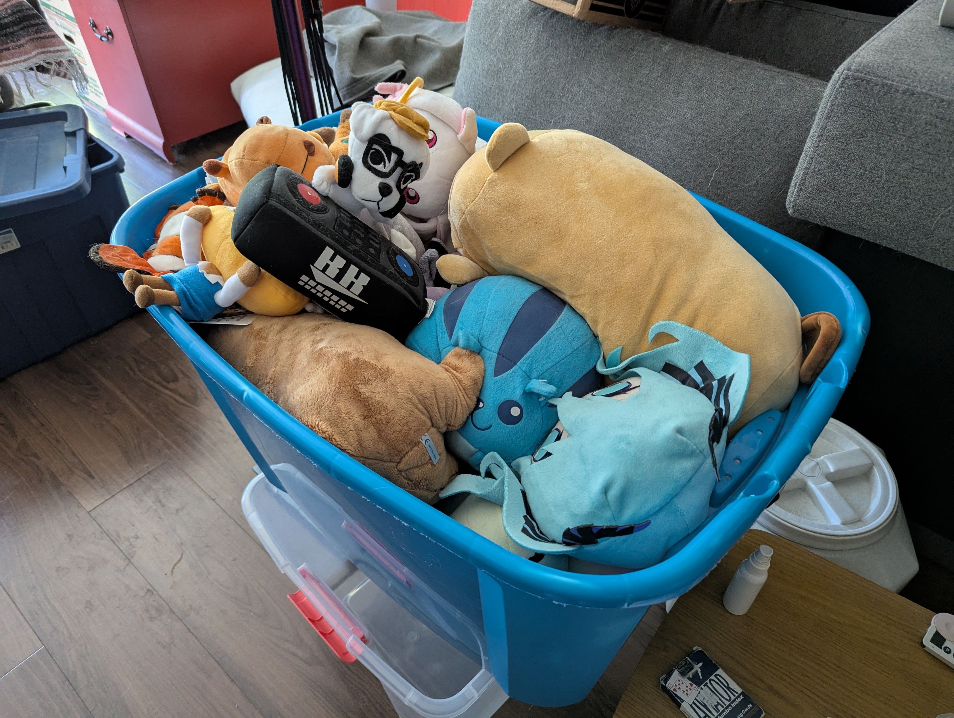 a blue plastic bin full of plushies of animals and random video game snd anime characters