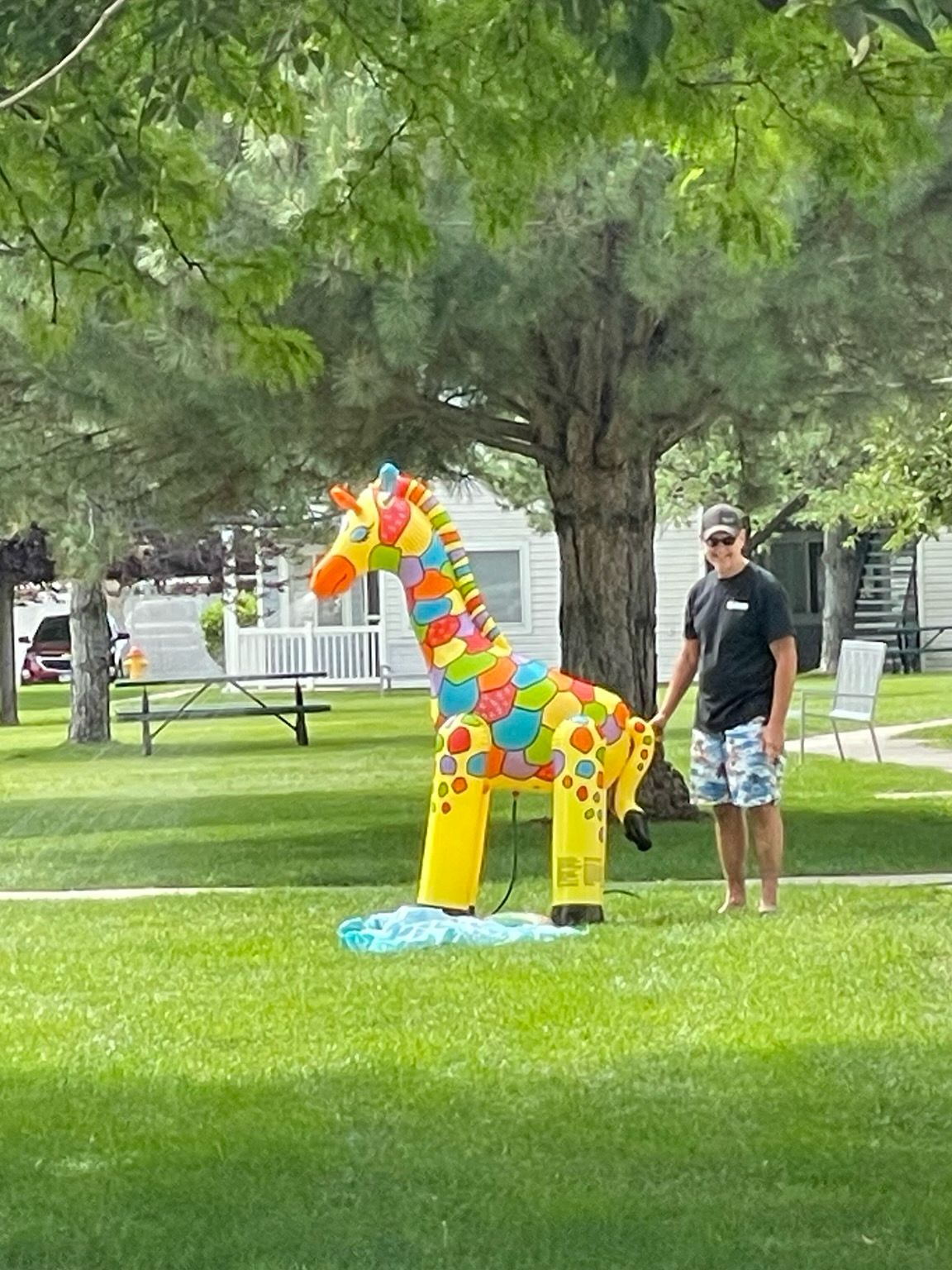 A colorful inflated unicorn squirts water out of its nose. 