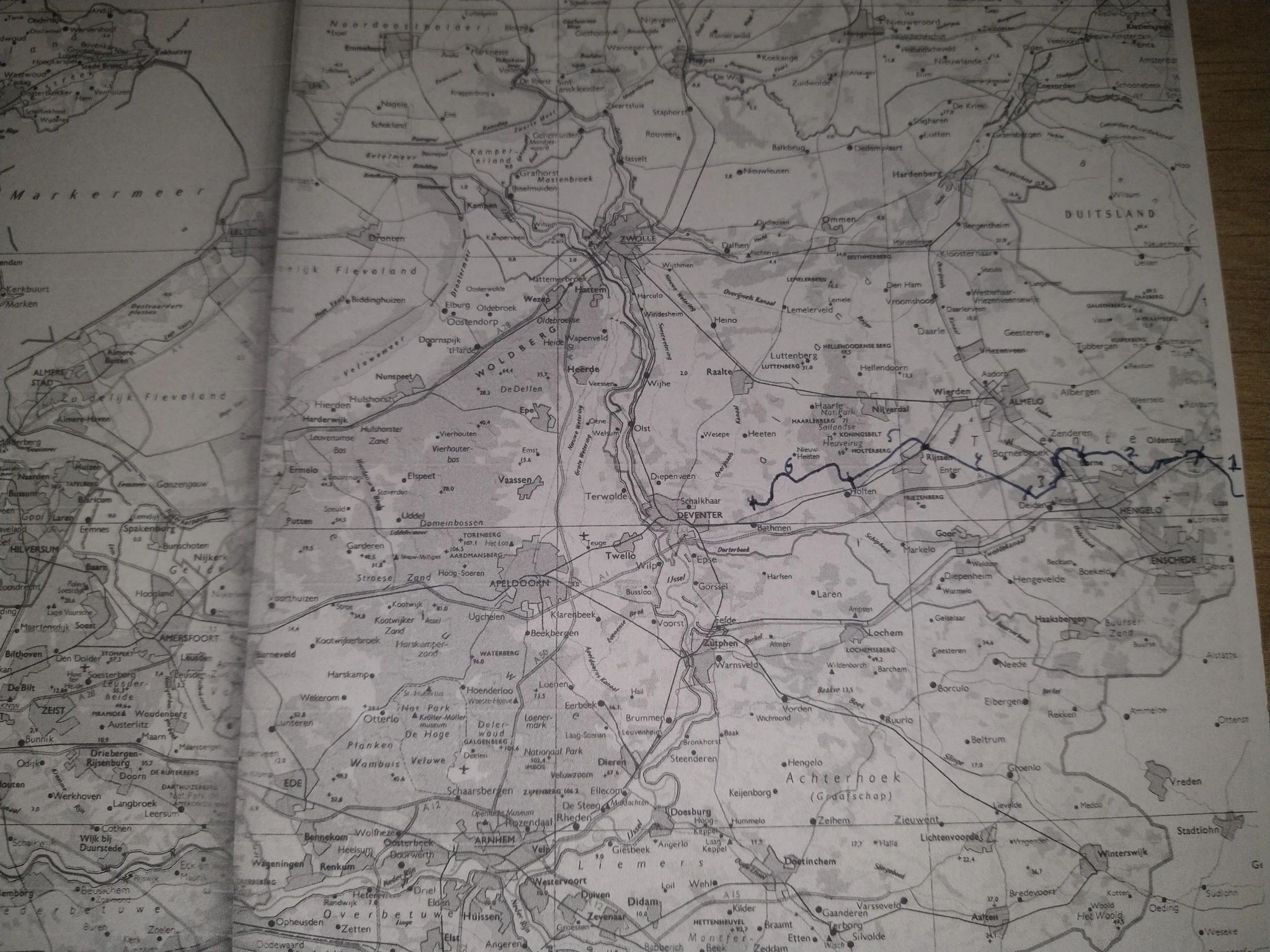 A greyscale photocopy of part of the Netherlands, with a blue line drawn from the right hand side, approximately following the route of the Marskramerpad. It's not very readable, but numbers and marks on the line indicate the separate legs. 