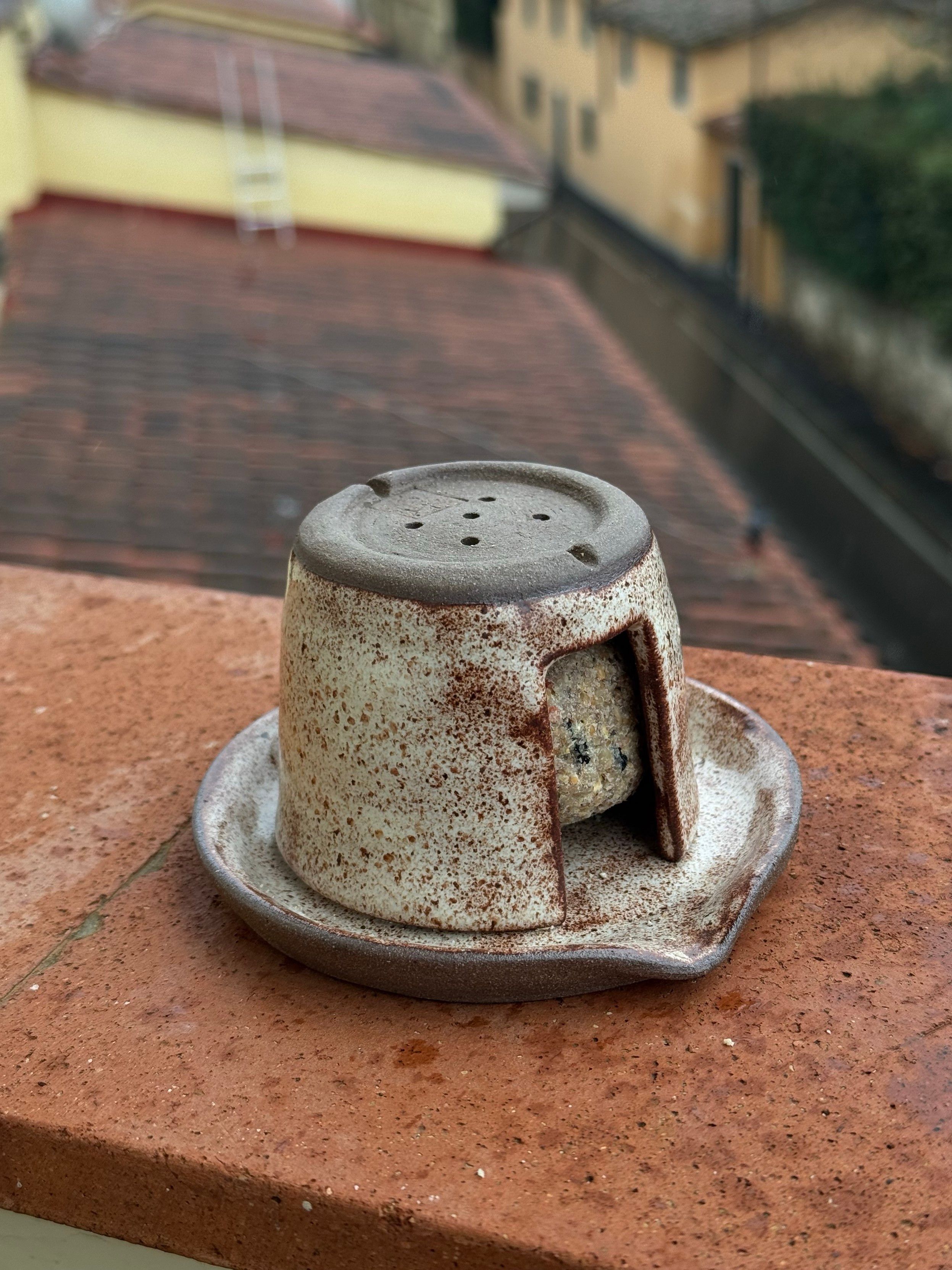 Tentativo di accrocco per ospitare palletta di grasso e semi riciclando miei coccini falliti. C'è una specie di piattino alla base, con sopra un vasetto aperto ai lati a chiudere la pallina. 