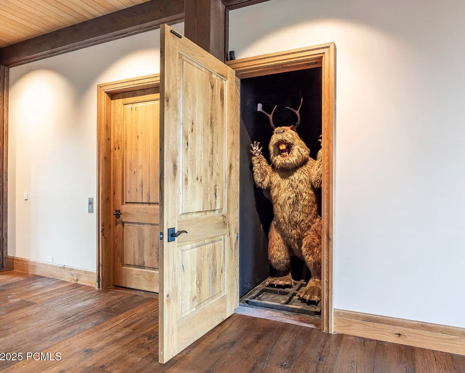 A door and inside is a very alarming person-sized statue of a beaver bearing its teeth