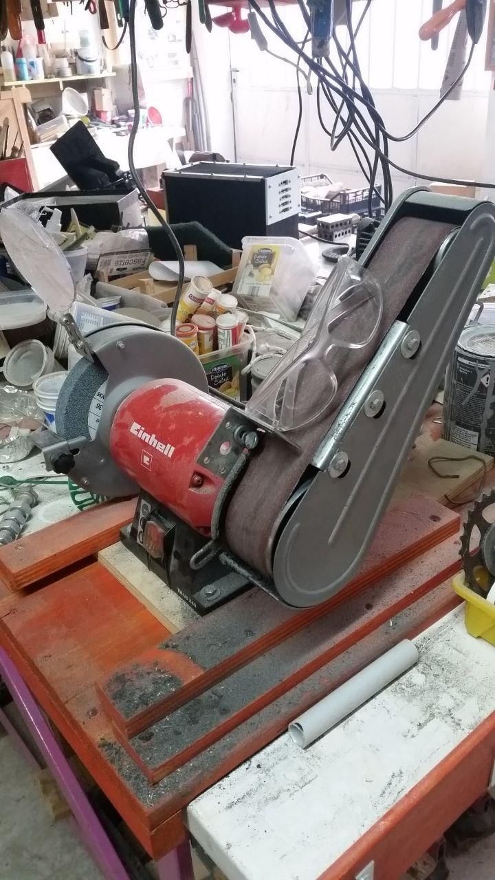 Levigatrice a nastro con occhiali di protezione appoggiati sul nastro.