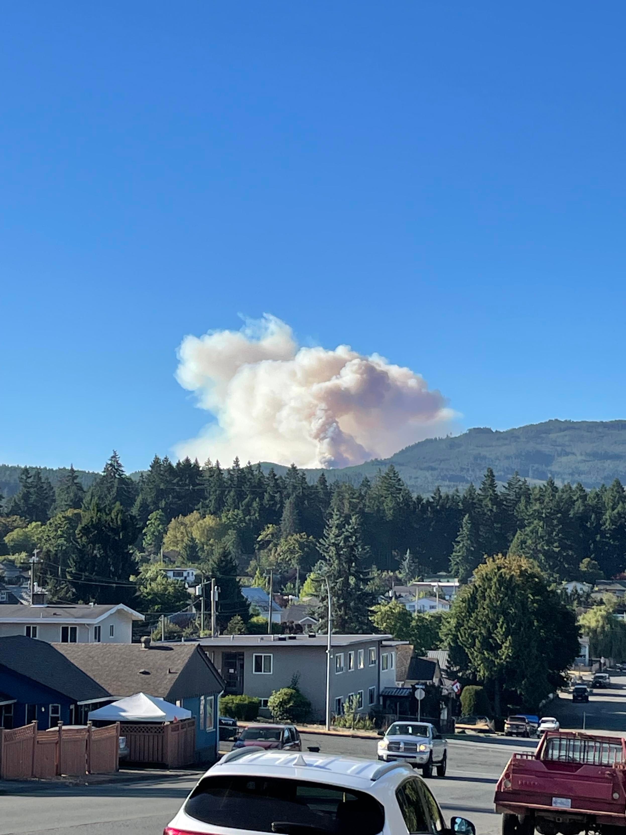 Smoke rises above the mountain in the distance
