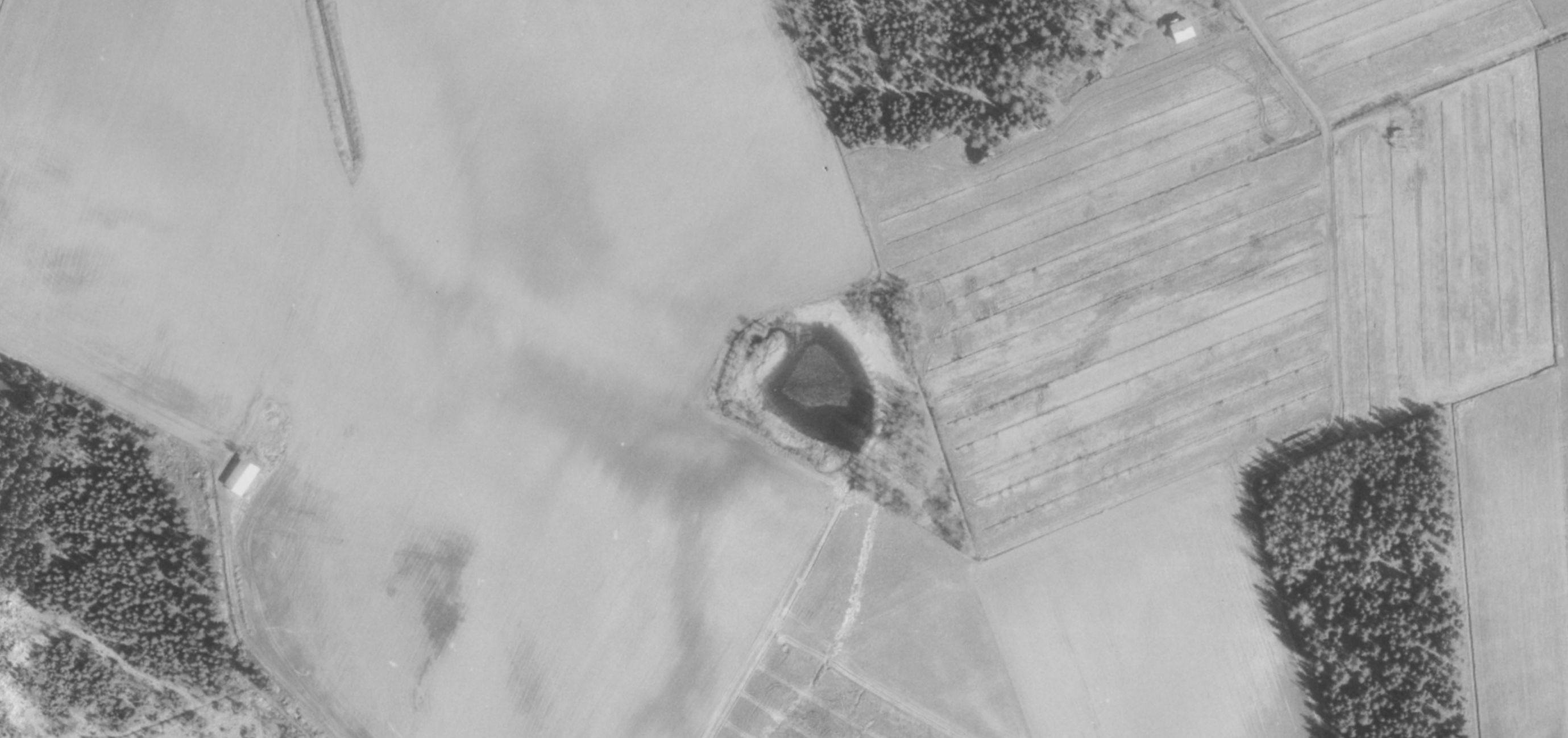 Ilmakuva, jossa peltojen keskelle jää avoin vesikuoppa.