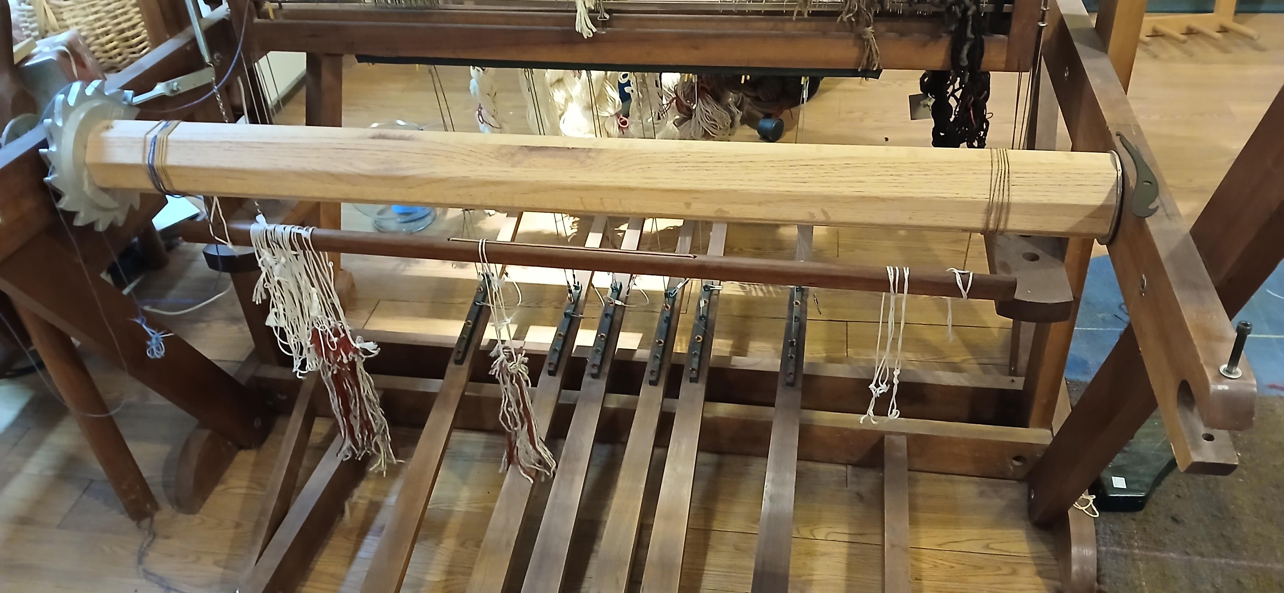 Apron bar hanging under the weft spindle