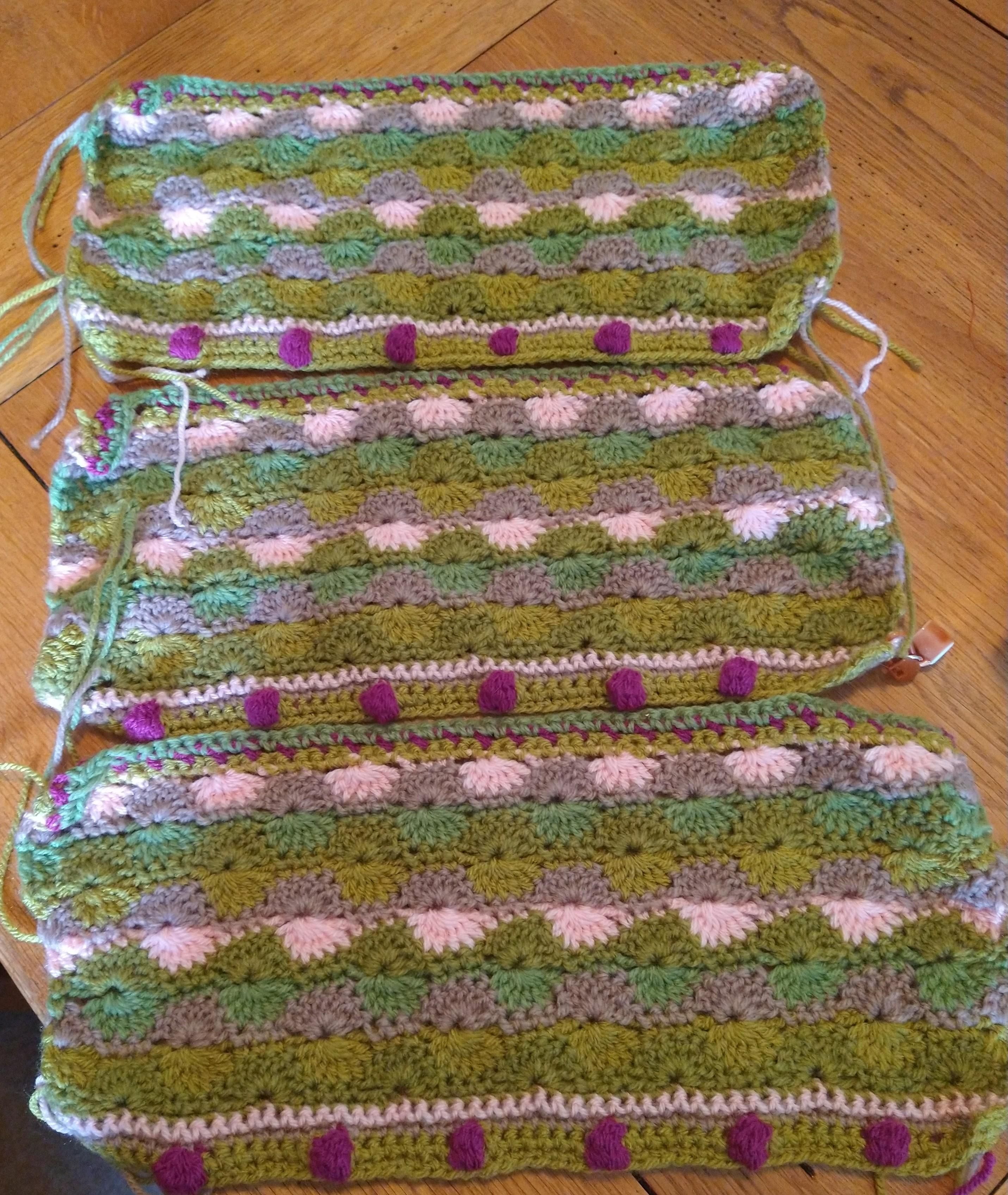 Three rectangular crochet pieces in pinks green and beige 
