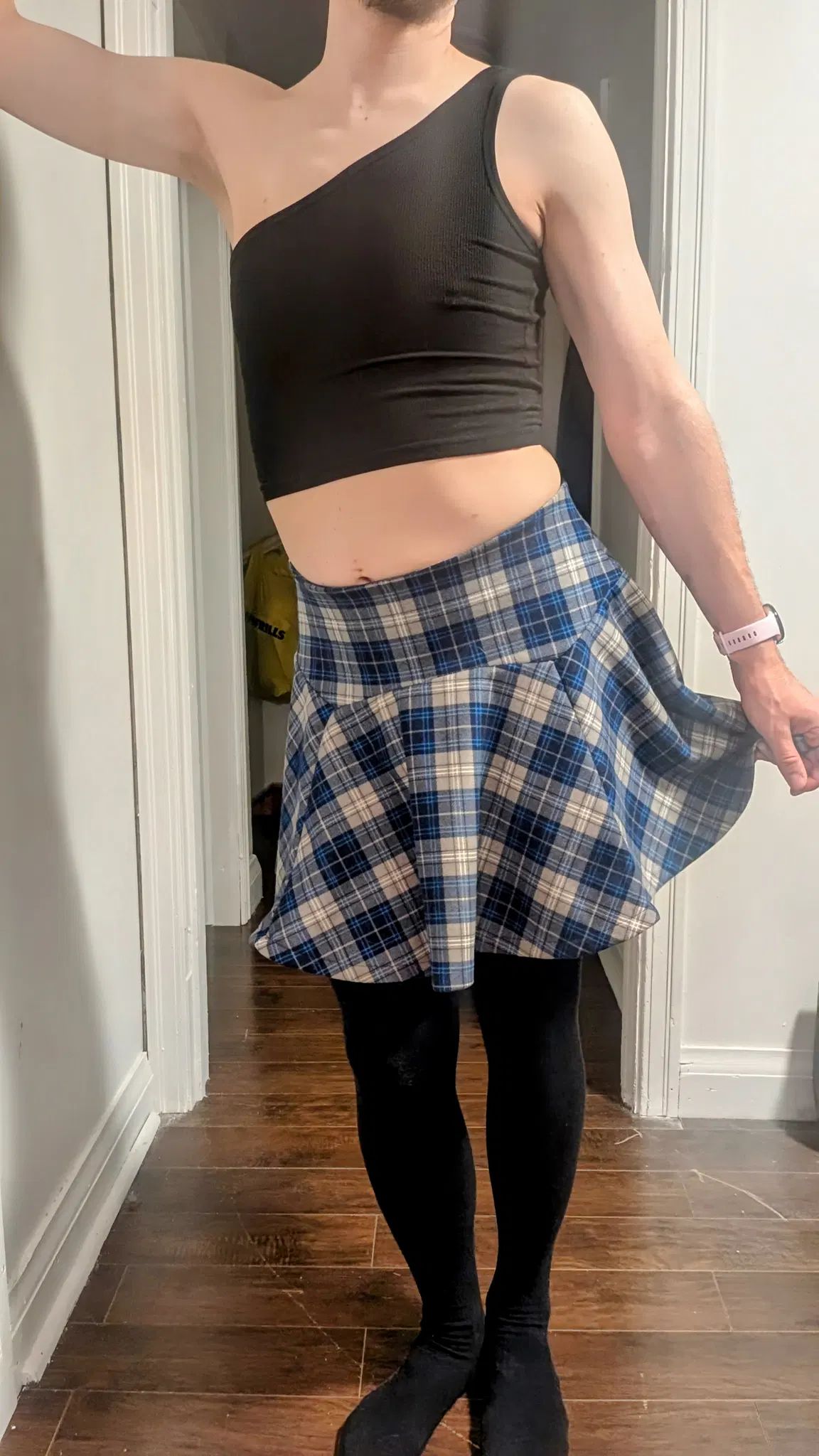 Leaning against the wall, he holds up his skirt in a flirty fashion. He knows that the skin he shows may make folks think he is willing to do more than just flirt.

And they would be right. He flirts because he wants to be seen. Undressed physically and in people's minds. What lewd thoughts might people think? How much is he willing to show? Will he lift the skirt up all the way?