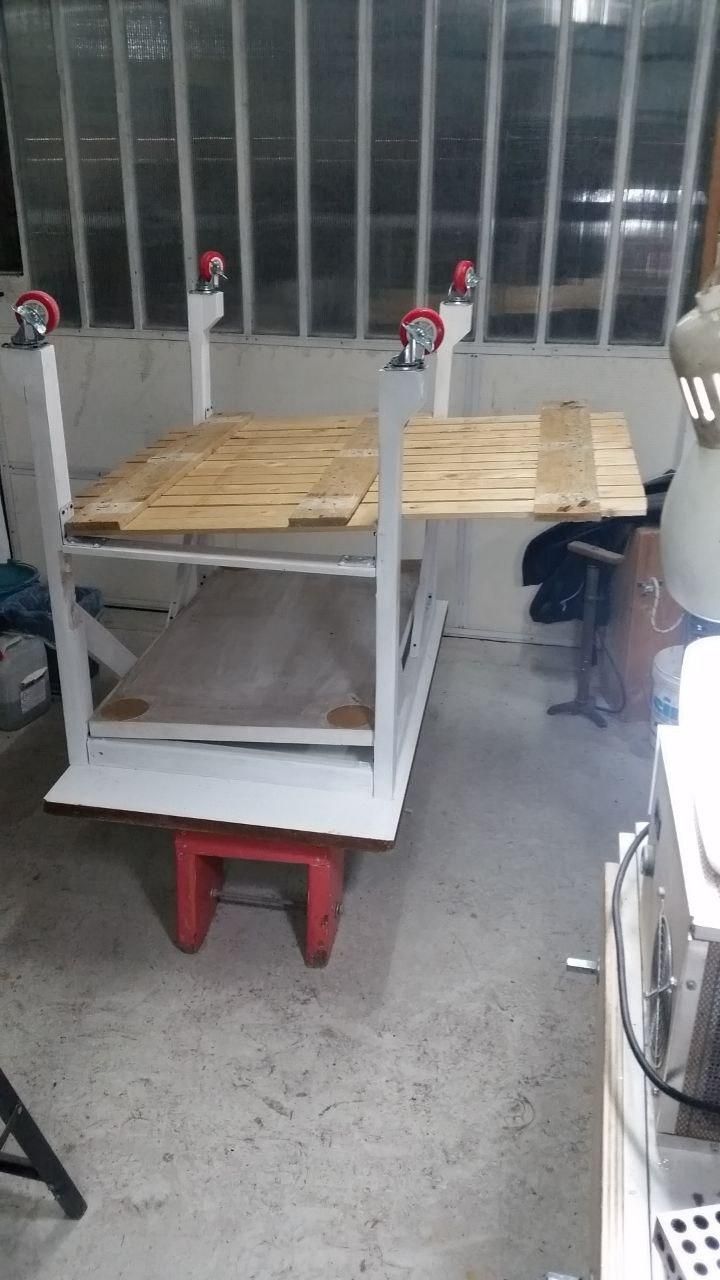 Ripiano di bancale infilato tra le zampe del tavolo.
Ne spunta una quarantina di cm.