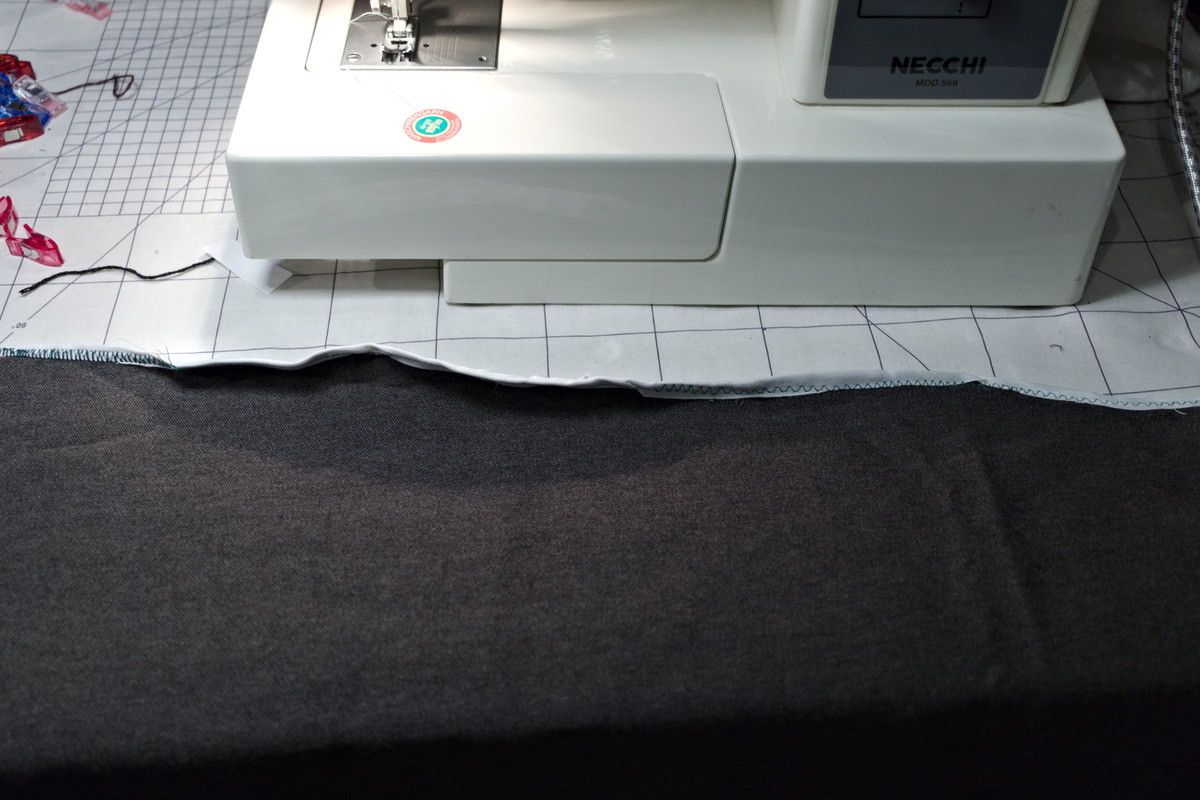 A fabric edge, bound in tape, that is warped and twisted like hell.