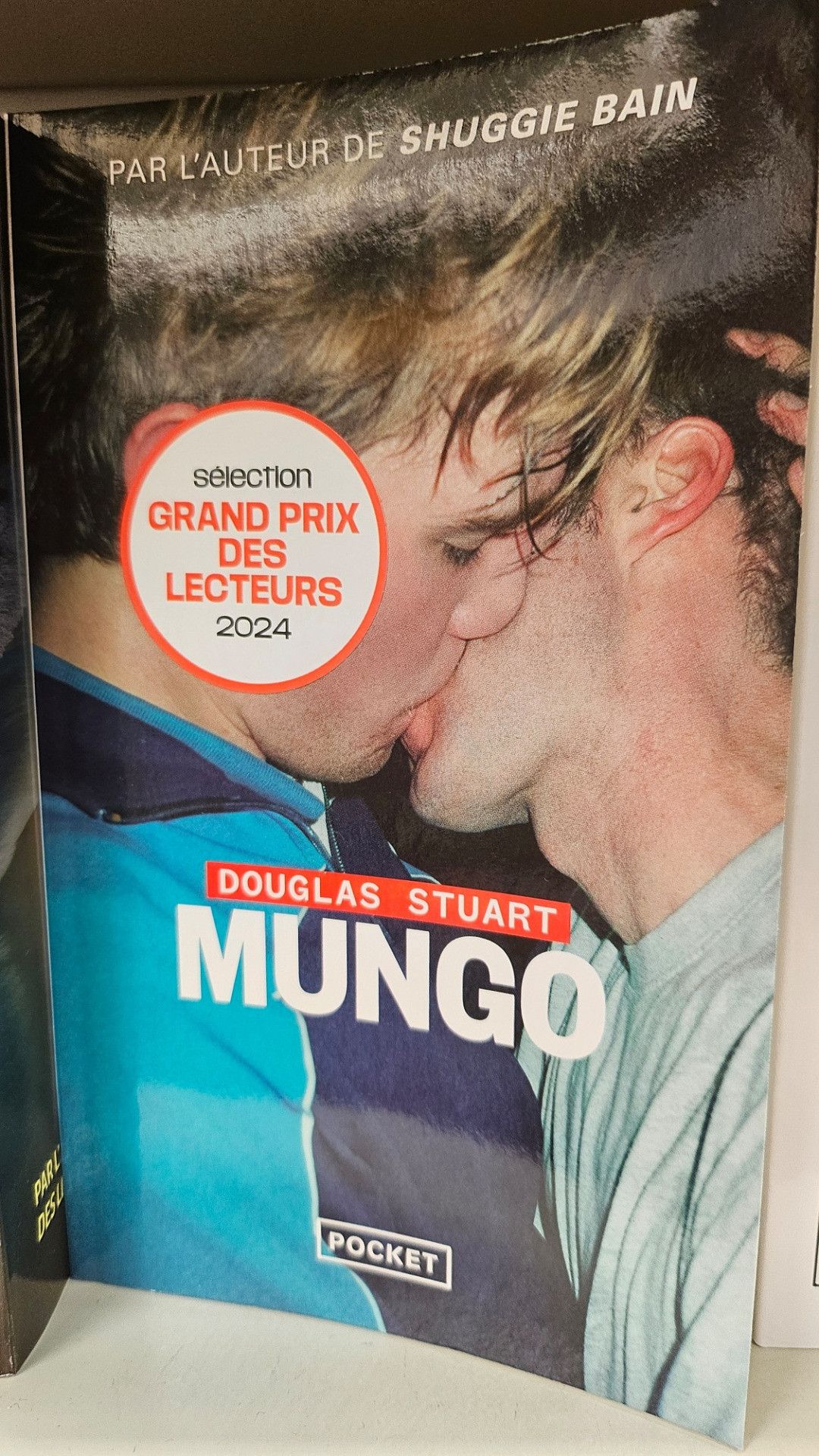 Livre de poche avec deux jeunes hommes qui s'embrassent la photo semble amateur (flash violent), le peu qu'on voit des fringues m'évoque les années 1990
Auteur Douglas stuart 
titre Mungo
macaron sélection Grand prix des lecteurs 2024
