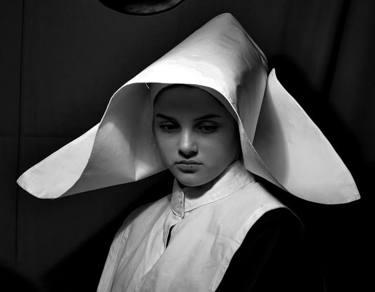Nun with what looks like wings as a veil sticking out from her ears.