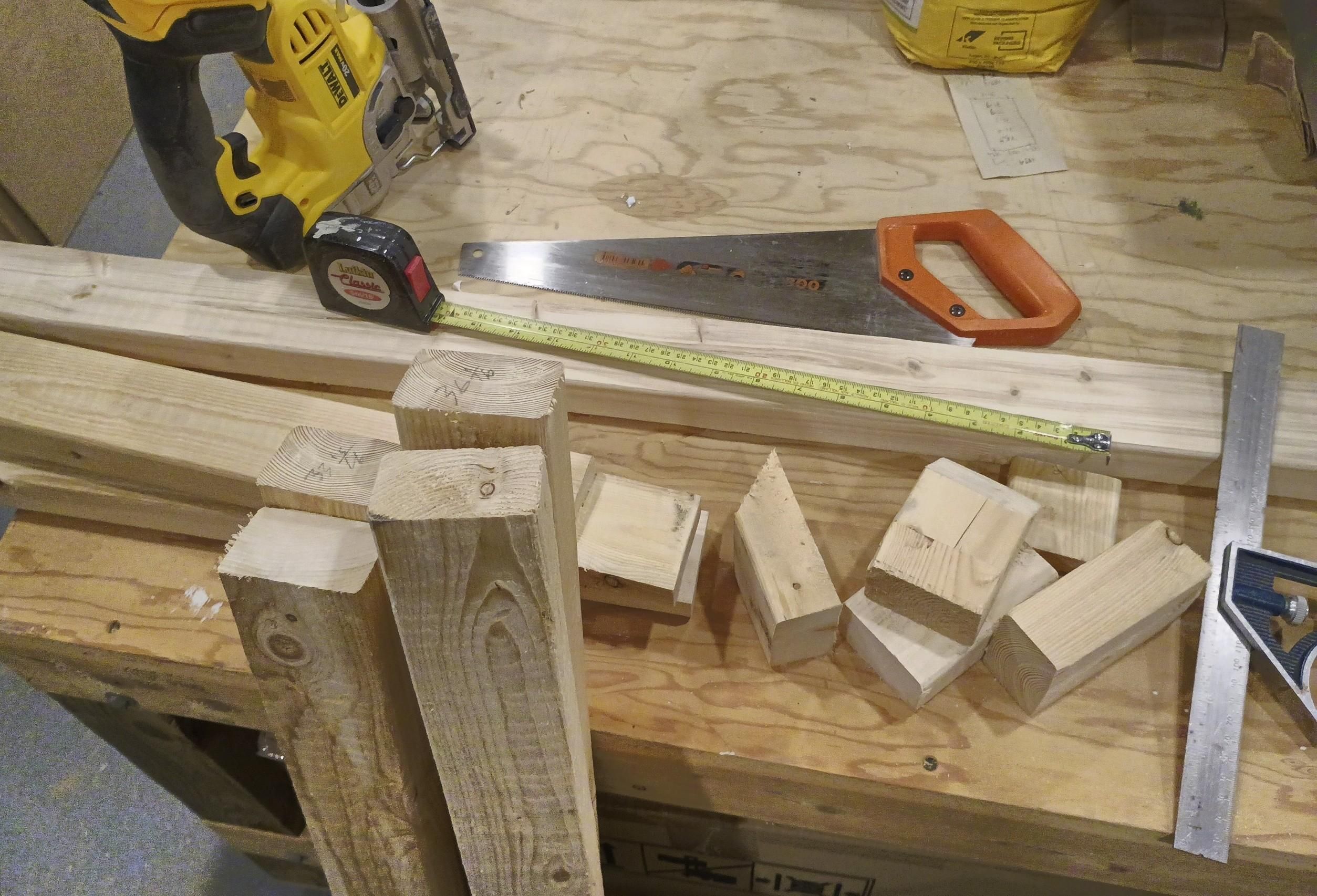 A bunch of wood pieces, some cut, some awaiting a saw. Both a handsaw and a power jigsaw are handy for the task.