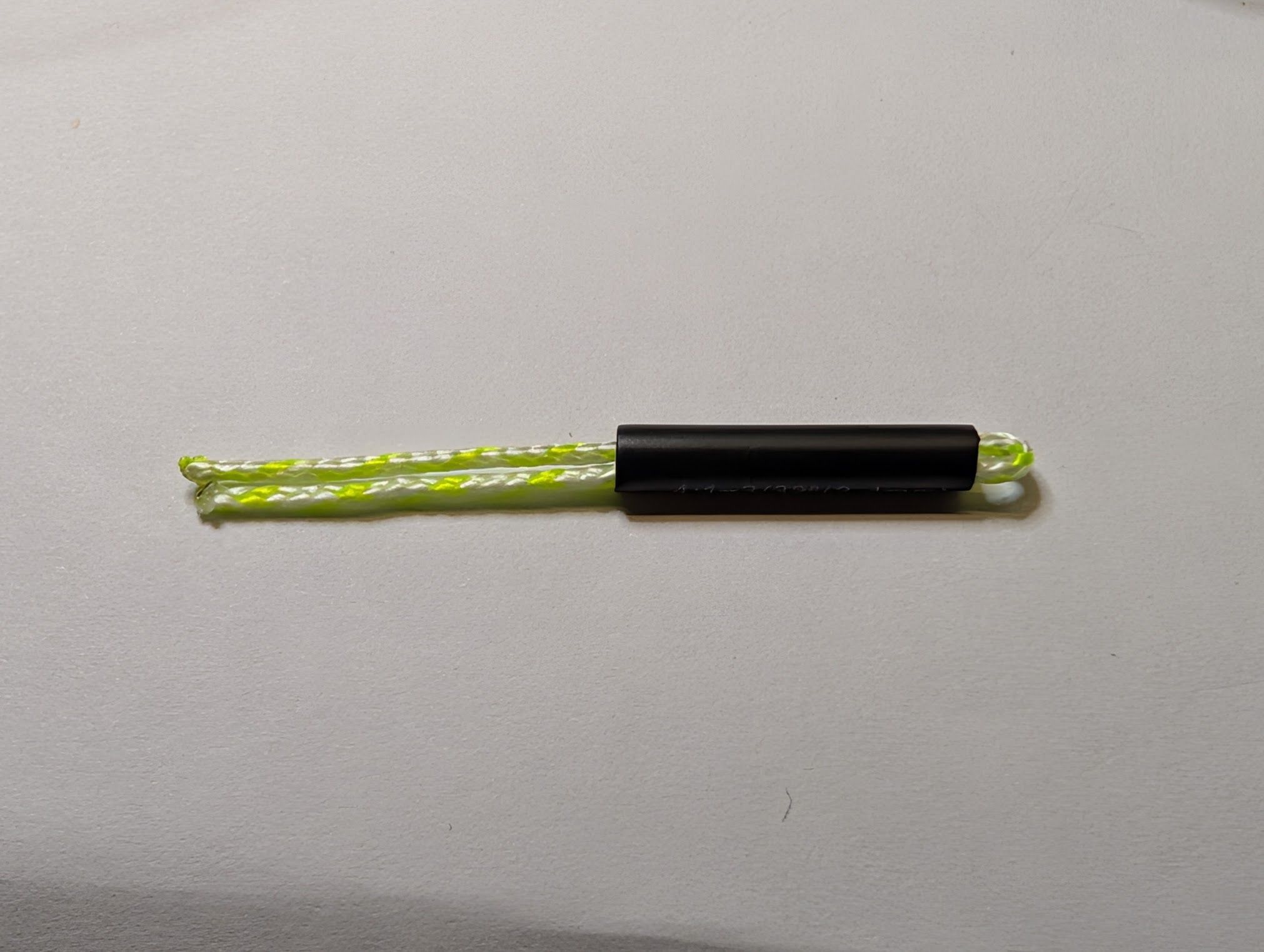 A piece of doubled dacron line partially inside a heat shrink tube