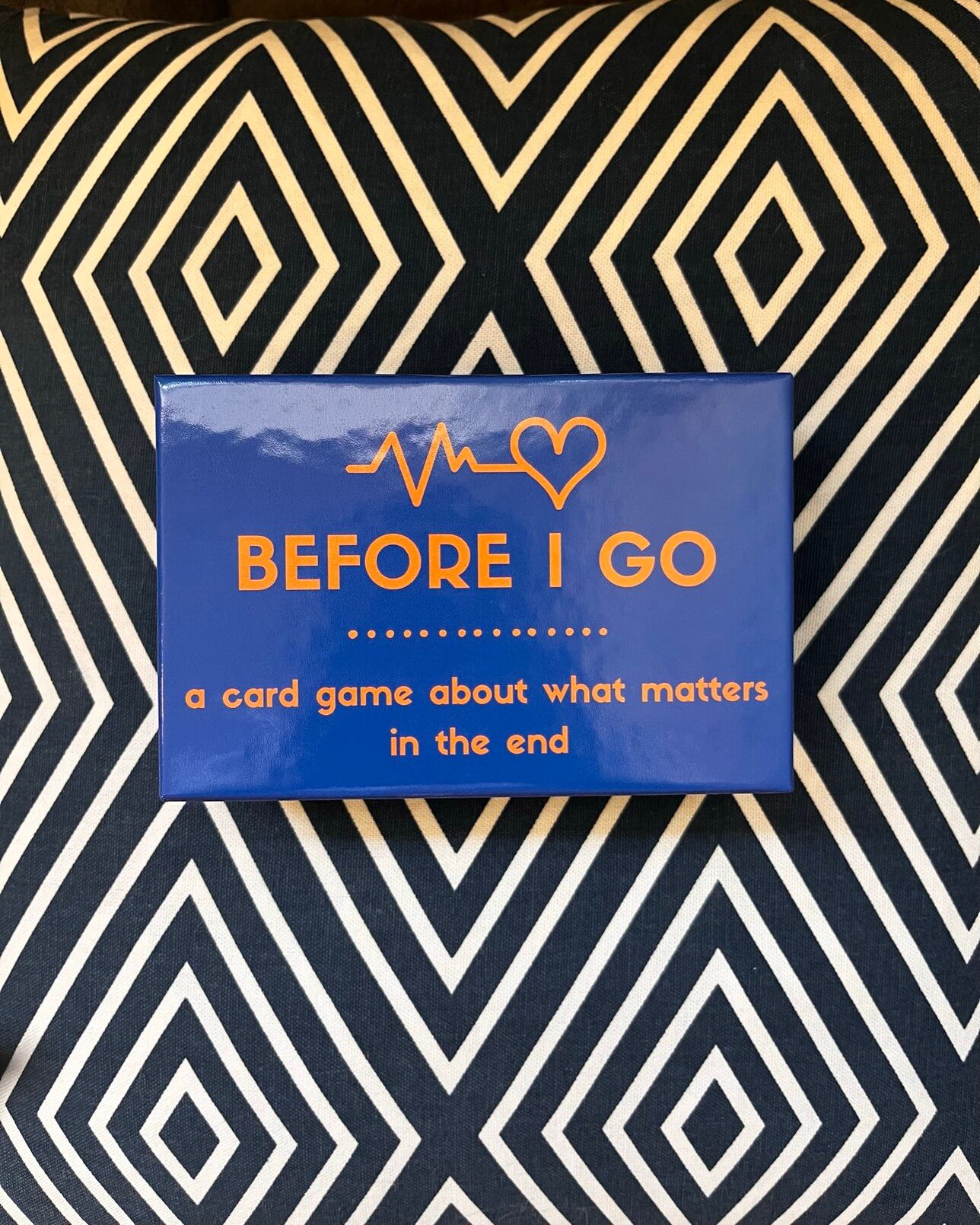 A blue box card game that says Before I Go: cal card game about what matters in the end
