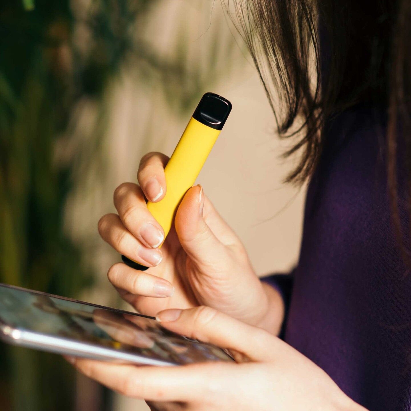 Picture of a woman with an e-cig in her hands.