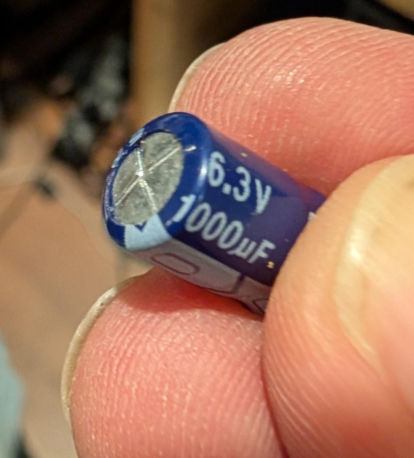 A 1000uF electrolytic capacitor that is domed.