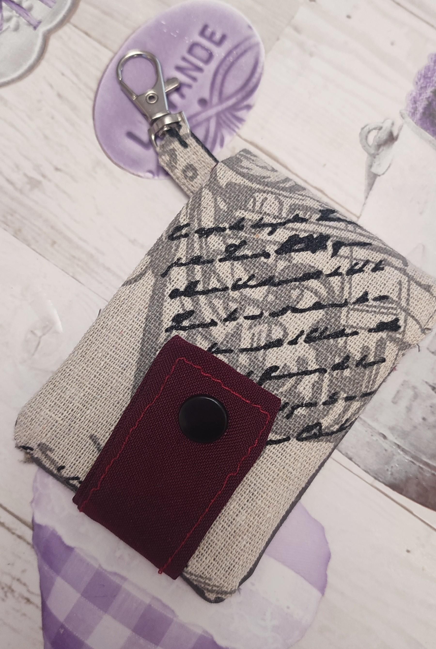 Open Keyring with card-holder handmade. Fabirc is a whitish colour wit the closure that is red and a black snap button. 