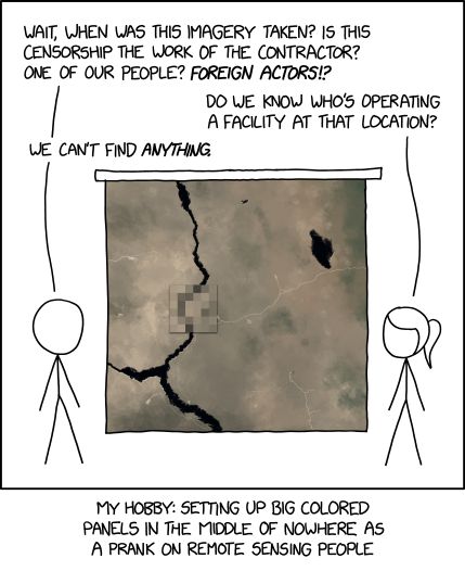 Single panel comic.

No hair and pony tail are standing on either side of a presentation screen with a satellite image. There is a small square in the middle that is very pixelated but still follows the general outline of the terrain. 

No hair says "Wait, when was this imagery taken? Is this censorship the work of the contractor? One of our people? *Foreign Actors* !?"

Pony tail responds "Do we know who's operating a facility at that location?"

No hair answers "We can't find *anything*."

Lower caption: My hobby: setting up big colored panels in the middle of nowhere as a prank on remote sensing people.
