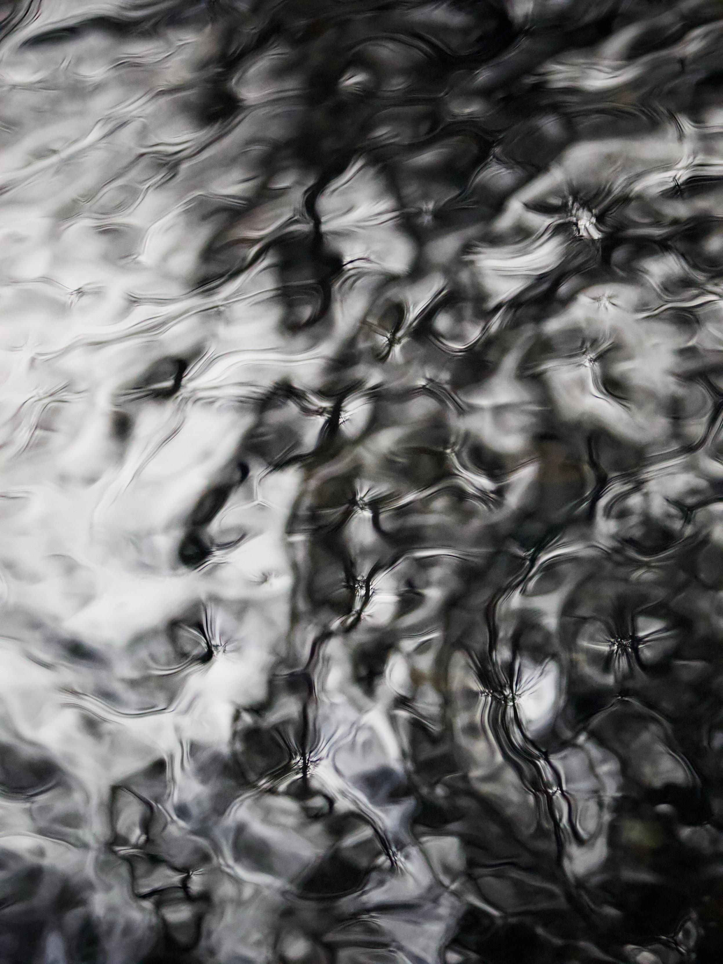 Ripples and reflections in the calmer pools on a fast-moving stream create beautiful shapes and textures where low winter sunlight catches the surface of the water