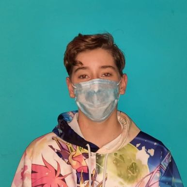 me in front of a blue background wearing a blue mask and a no game no life anime hoodie, i have short hair and generally look like a boy