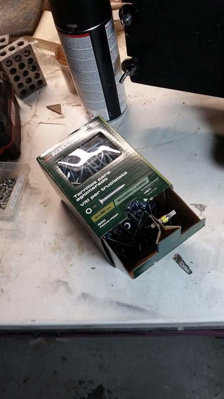 Scatola di viti con inserto Torx infilato in una linguella del coperchio.