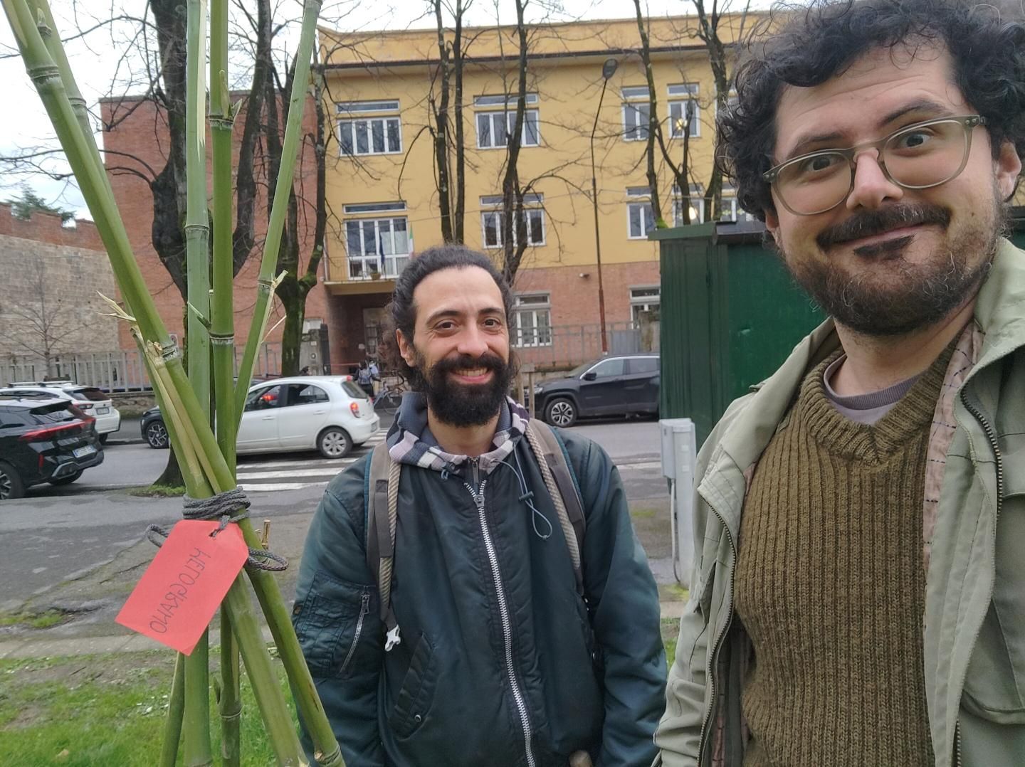 Gabriele e Luca in posa davanti il cannicciato di un melograno. con alle spalle la scuola primaria "Damiano Chiesa" a Pisa