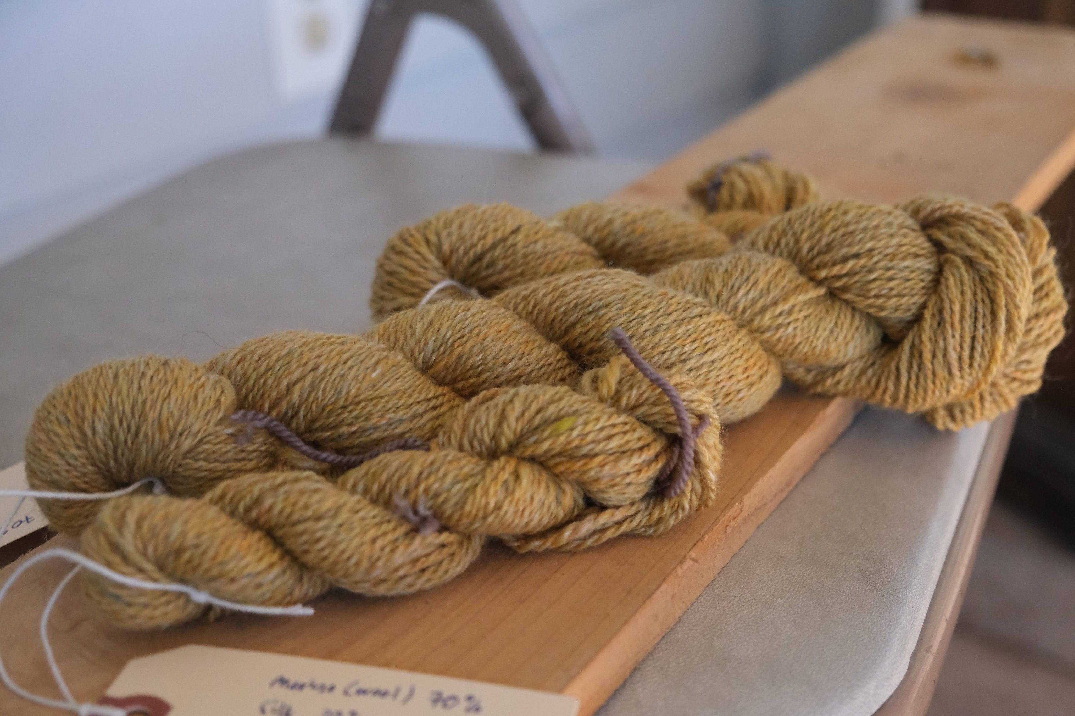 lightly variegated golden handspun yarn. 3 skeins - 1 large and 2 small. it's a 2ply and it's a 70/30 merino/silk blend 
