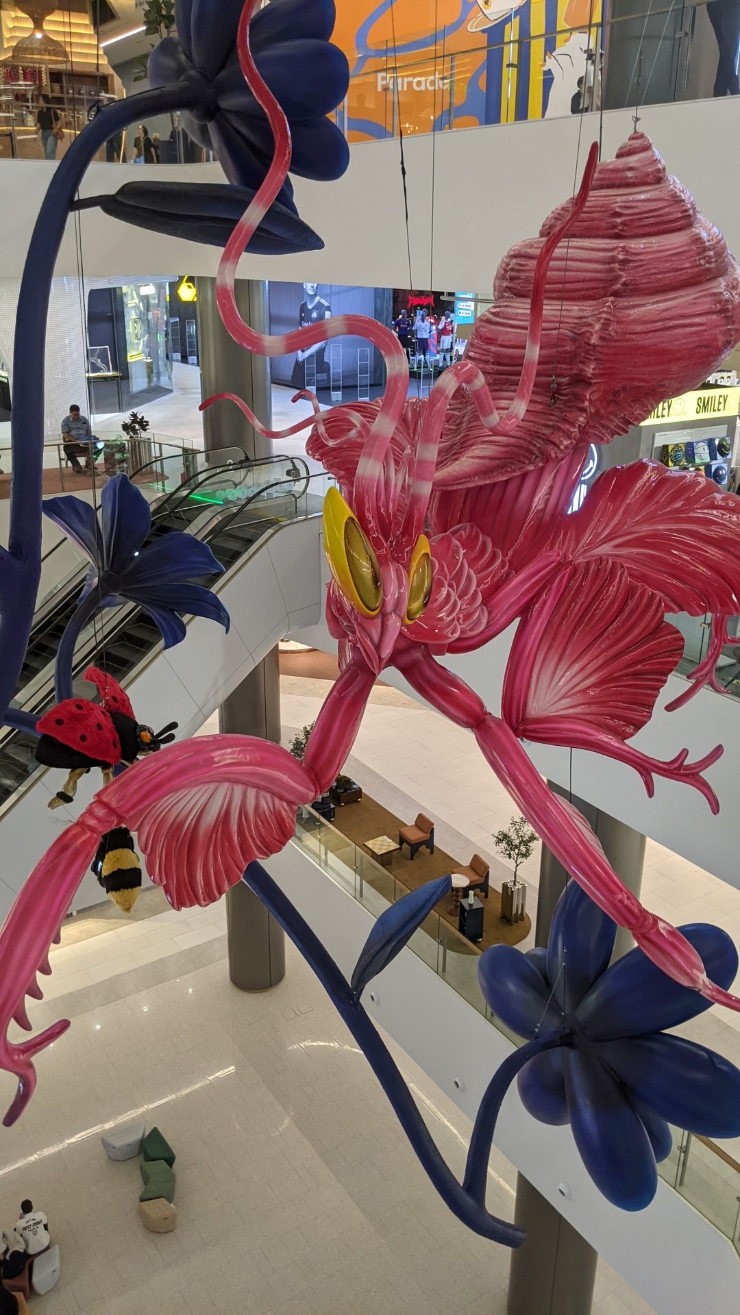An absolutely enormous, hot-pink hanging sculpture in the atrium of a multi-story mall, of what looks like a wily shrimp dancing out of a conch shell, surrounded by huge hanging sculptures of dark blue flowers. I don't know, man. Seeing this didn't help my jet lag.