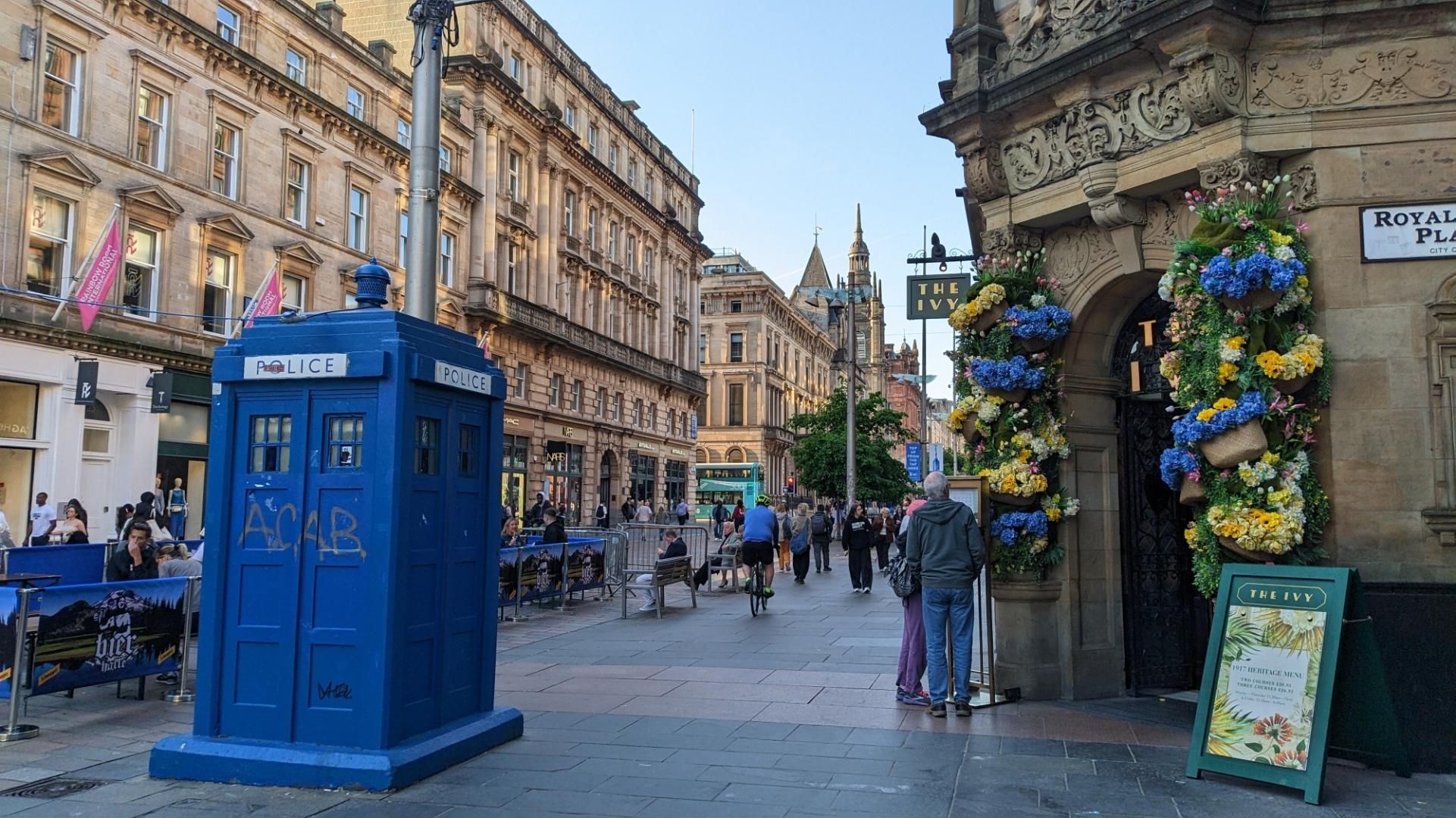 busy street with tree amd blue police box