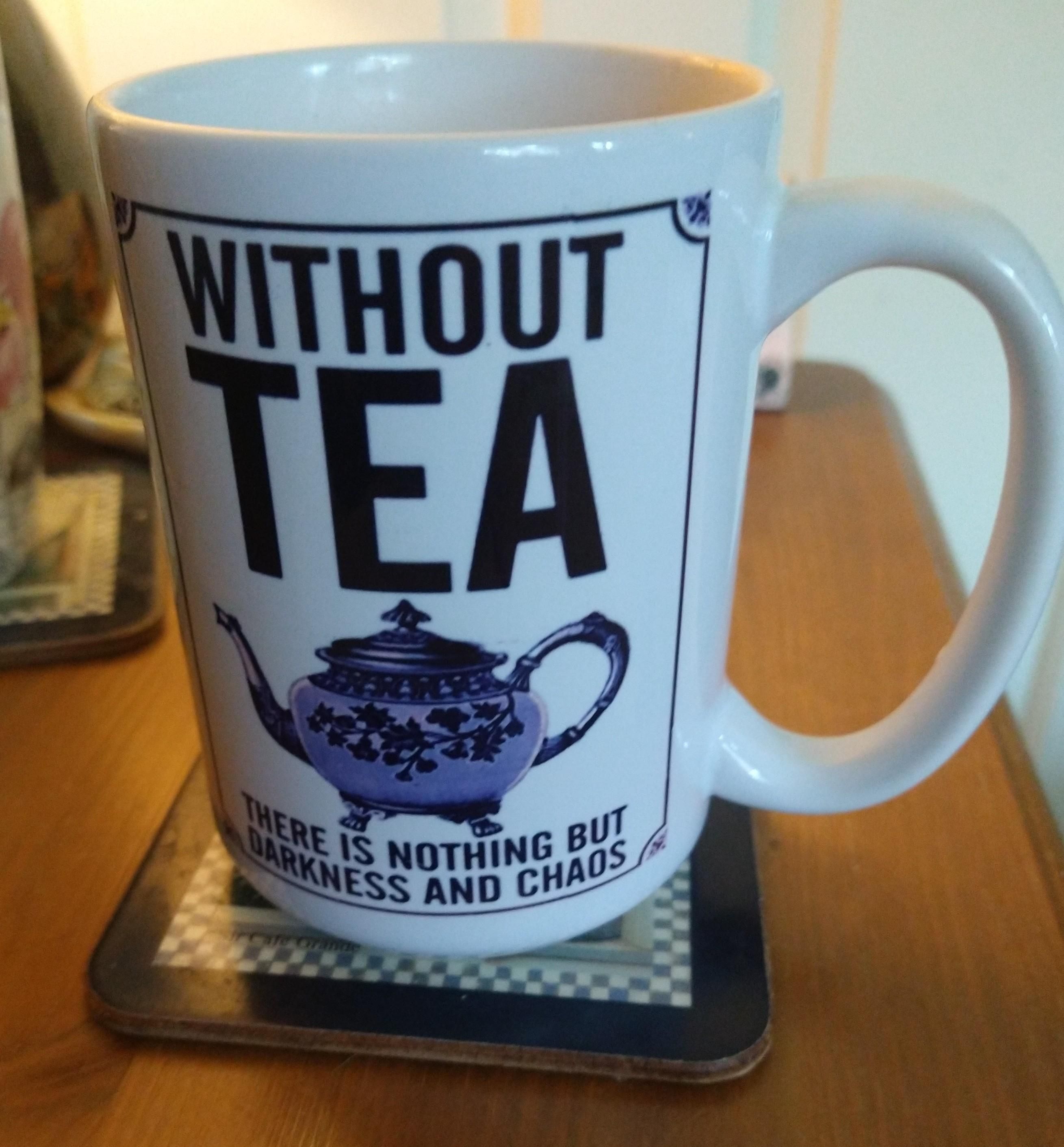 Mug of tea on a bedside cabinet, with the words 'Without tea there is nothing but darkness and chaos' 
With a pink teapot in the centre 